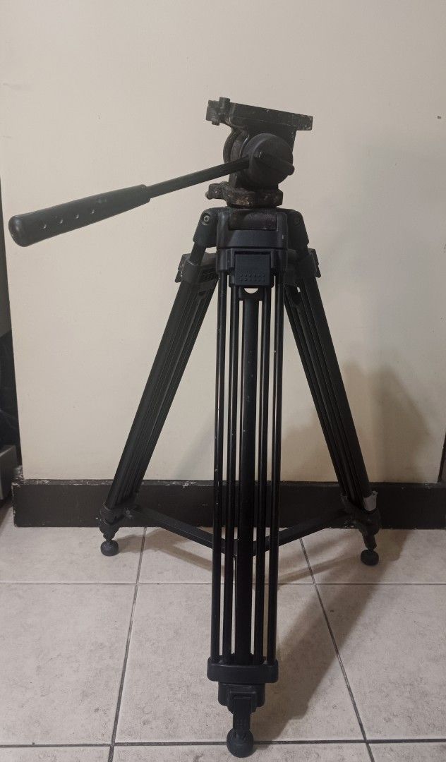 Professional Video Tripod (Category: Tripods & Monopods) located in Paranaque City. Submitted by phcoincollective (Listing ID 1420226550, Image 2). Description: - Professional video tripod - Adjustable legs for versatile setup - Fluid head for smooth panning and tilting - Includes a handle for easy control - Provides stable support for cameras and camcorders - Perfect for indoor and outdoor shoots.
