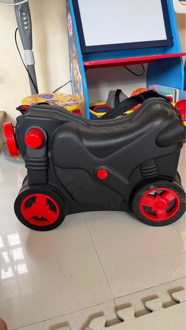 Ride-on Motorcycle Suitcase Luggage (Category: Luggage) located in Binan City. Submitted by gia.declutters (Listing ID 1420175384, Image 1). Description: - Motorcycle-style ride-on suitcase - Black with red wheel and accent design - Made of durable plastic - Features a handle for carrying - Opens up for storage - Fun and functional for kids RFS: outgrown no issues Perfect pang aliw sa airport.