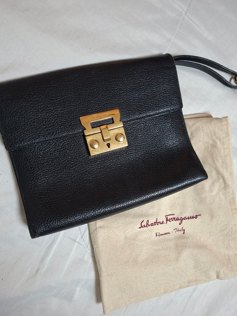 Salvatore Ferragamo Black Clutch (Category: Luxury Bags & Wallets) located in Ilagan. Submitted by dbankerscloset (Listing ID 1420305351, Image 1). Description: - Salvatore Ferragamo black clutch - Gold-tone clasp closure - Includes dust bag - Interior with multiple compartments - Features a wrist strap.