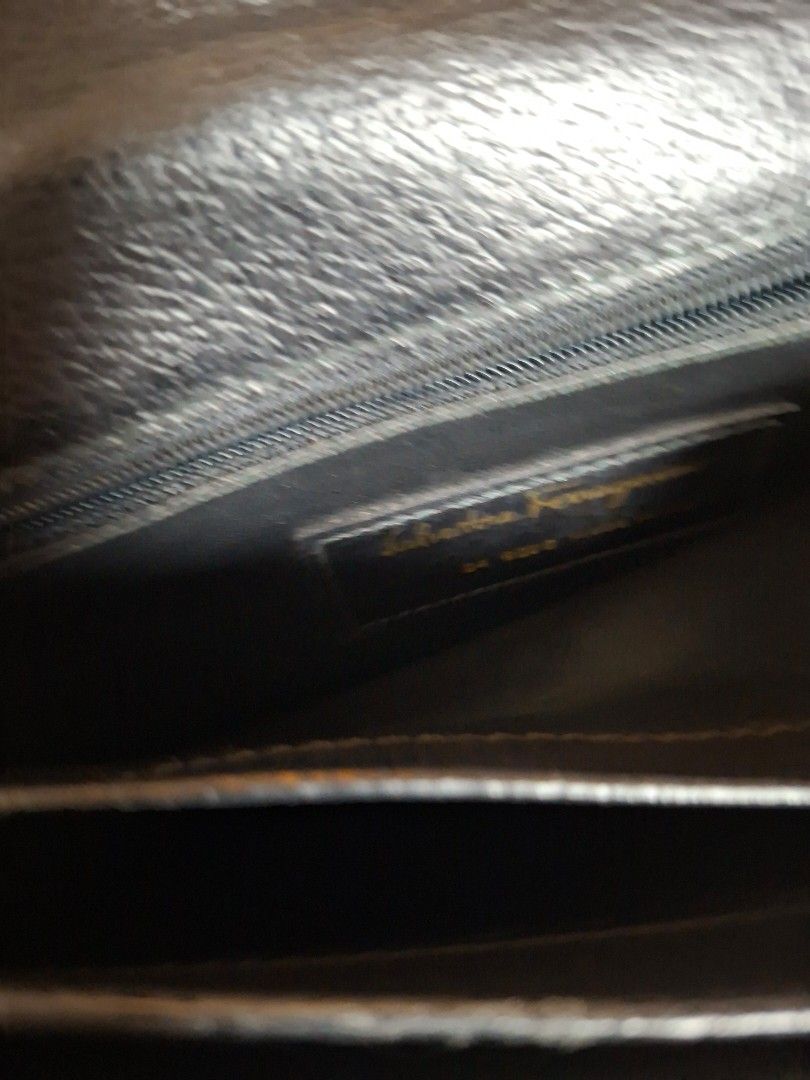 Salvatore Ferragamo Black Clutch (Category: Luxury Bags & Wallets) located in Ilagan. Submitted by dbankerscloset (Listing ID 1420305351, Image 3). Description: - Salvatore Ferragamo black clutch - Gold-tone clasp closure - Includes dust bag - Interior with multiple compartments - Features a wrist strap.