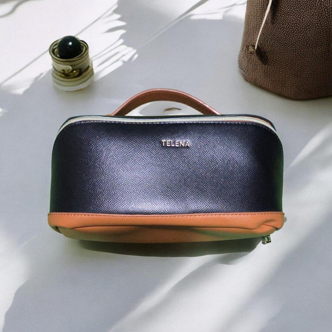 Telena Cosmetic Bag with Handle (Category: Purses & Pouches) located in Manila. Submitted by womensphstuff (Listing ID 1420280904, Image 2). Description: For sale: 500 Orig price: 3,000 - Telena cosmetic bag - Sleek black exterior with brown base and handle - Light beige interior - Multiple compartments for organization - Secure zipper closure - Easy to carry with handle.