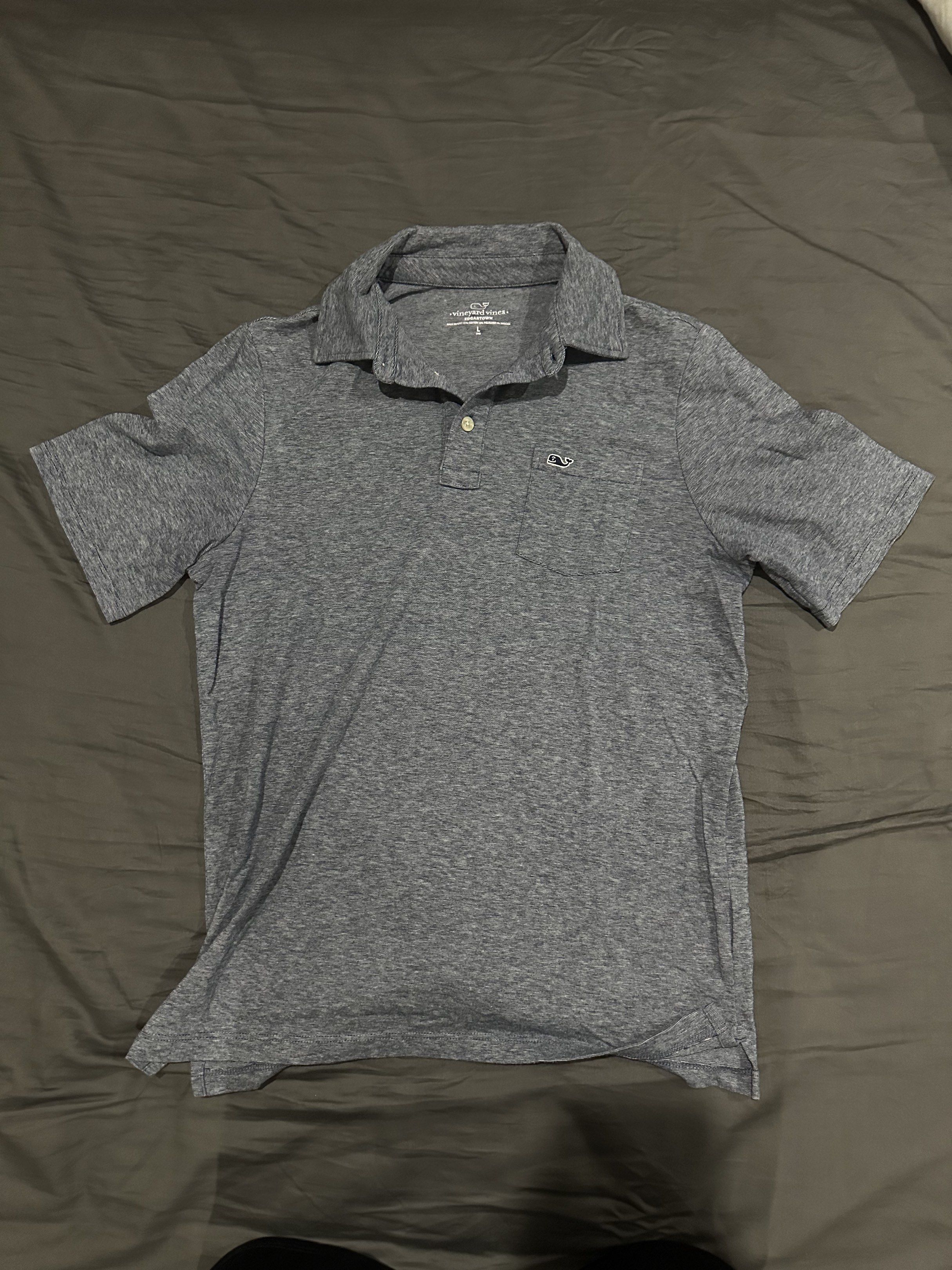 Vineyard Vines Polo Shirt (Category: Tshirts & Polo Shirts ) located in Pasig City. Submitted by chiccochoco (Listing ID 1420176660, Image 1). Description: - Vineyard Vines polo shirt in gray. - Features a chest pocket with the Vineyard Vines logo. - Classic polo collar with button closure. - Short sleeves. - Made from a lightweight fabric, perfect for casual wear..