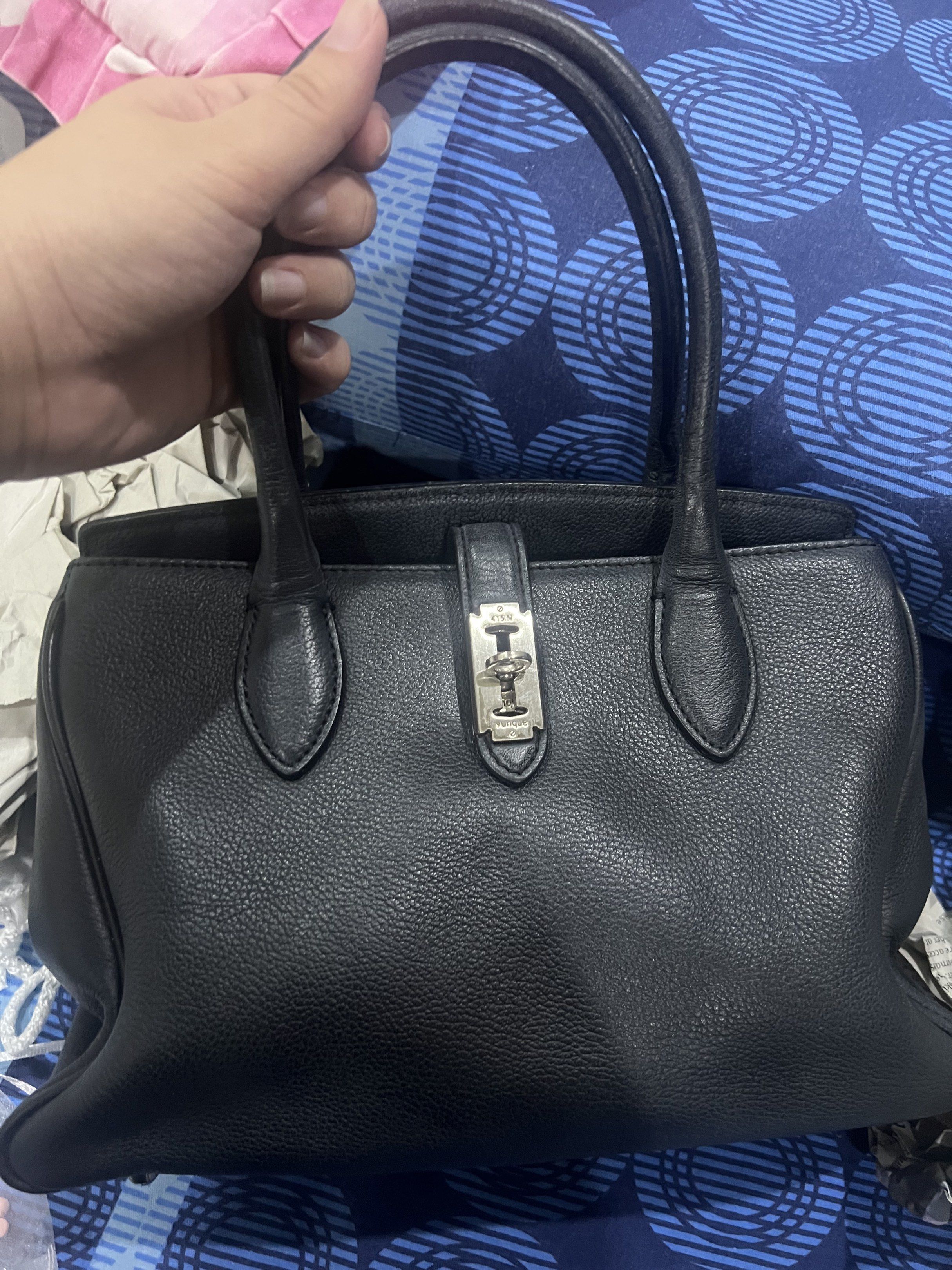 Vuque Toque Handbag with Shoulder Strap (Category: Luxury Bags & Wallets) located in Dasmarinas. Submitted by stuffsbyklay (Listing ID 1420290404, Image 1). Description: - Black Vuque handbag - Top handle and detachable shoulder strap - Silver-tone clasp closure - Fabric lining - Includes brand tag and product code - Made of textured leather - Classic, structured design .