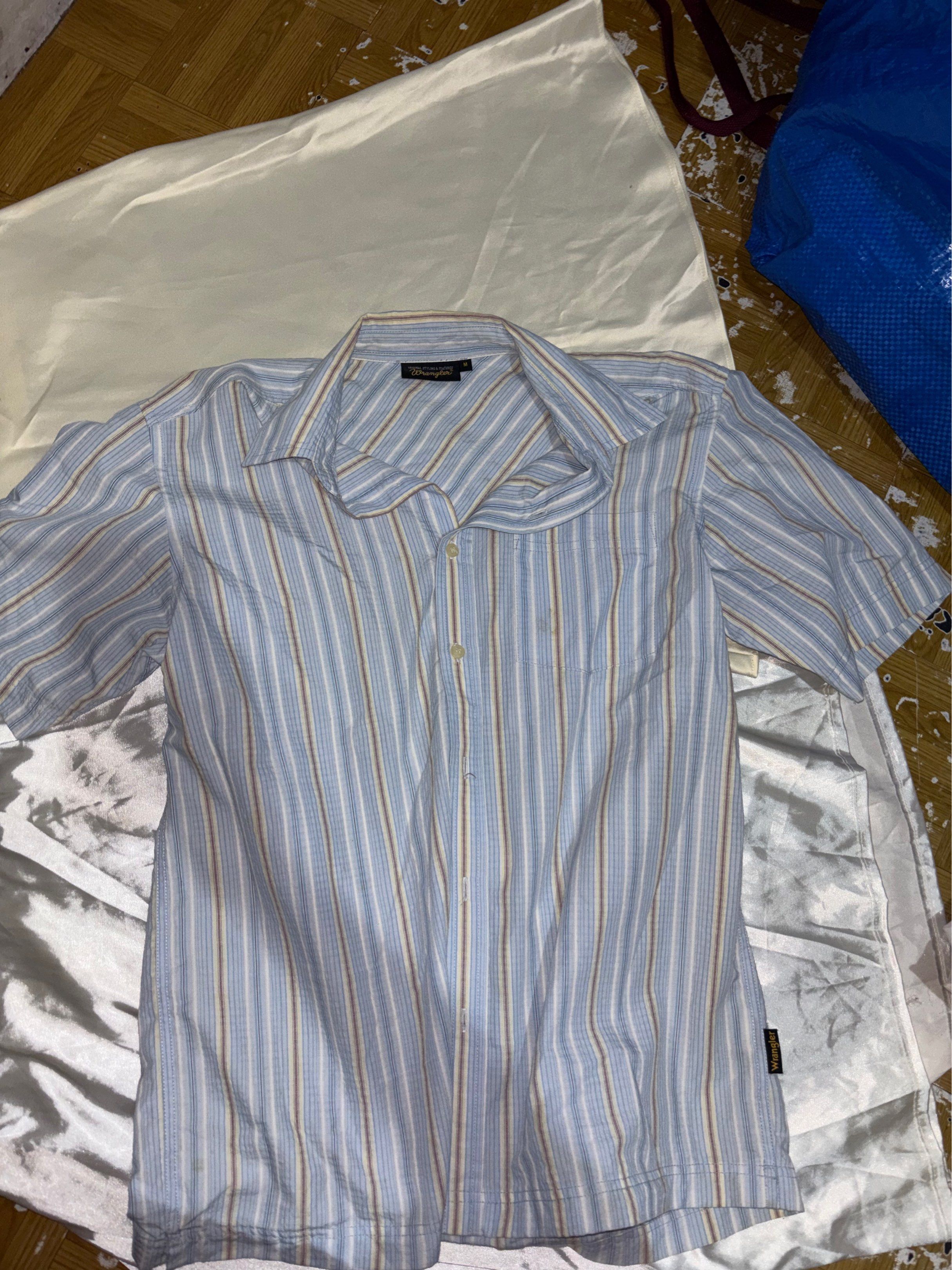 Wrangler Striped Short Sleeve Shirt - Medium (Category: Tshirts & Polo Shirts ) located in Mandaluyong City. Submitted by castpreloveds (Listing ID 1420304258, Image 2). Description: - Wrangler shirt - Striped pattern: Blue, white, brown - Short sleeves - Button-down style - Size: Medium - Features a chest pocket - Condition: Has a stain on the front.