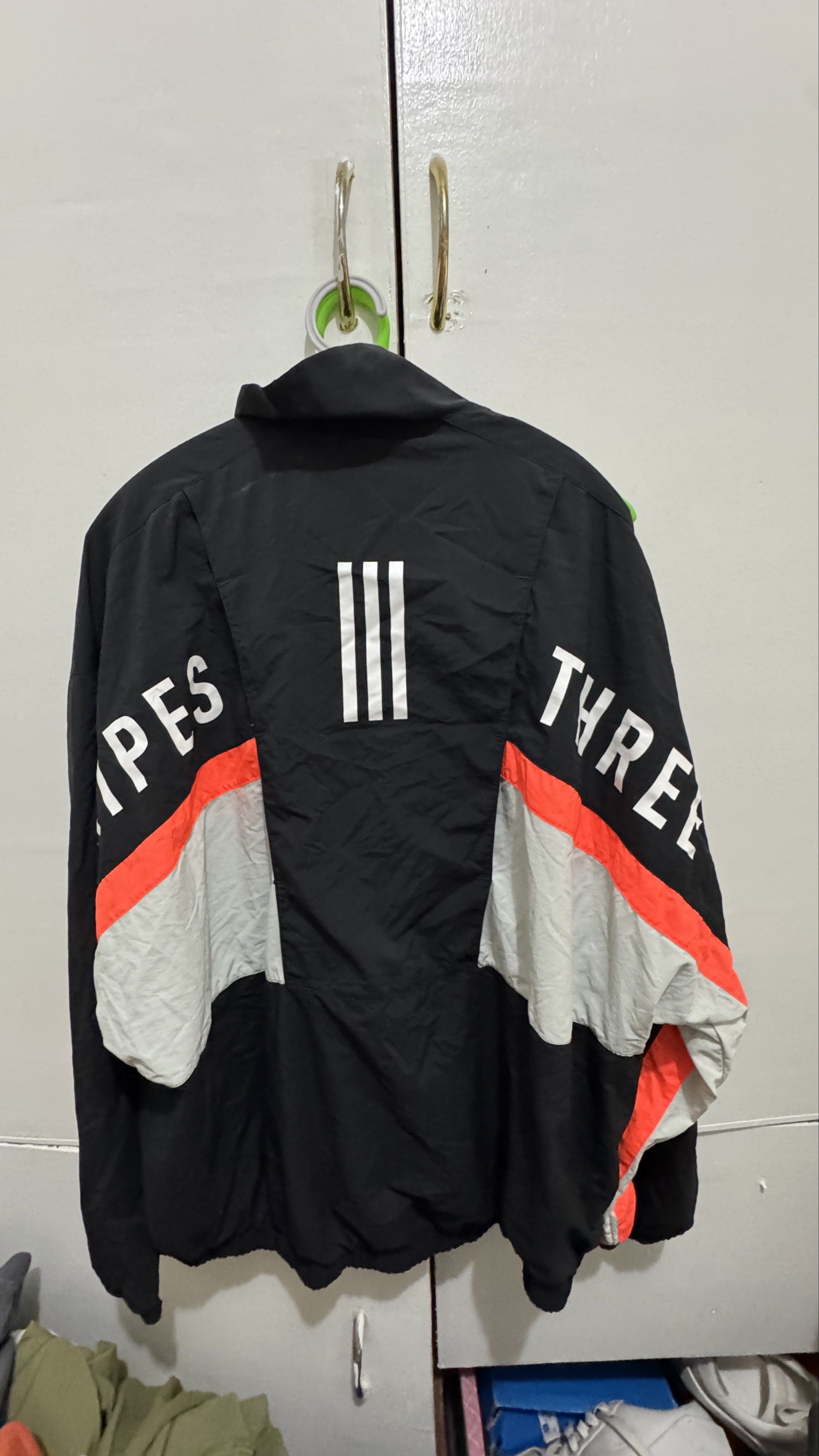 Adidas Three Stripes Jacket - Black (Category: Coats, Jackets and Outerwear) located in Manila. Submitted by offthehype (Listing ID 1420441387, Image 2). Description: - Adidas jacket in black with orange and grey accents - Size: L - Design: Iconic three stripes on the back and "THREE STRIPES" print on sleeves - Features: Mesh lining, zipper closure - Material: Nylon and polyester blend - Boxy cropped fit I can give 1800 for the set if set kukunin