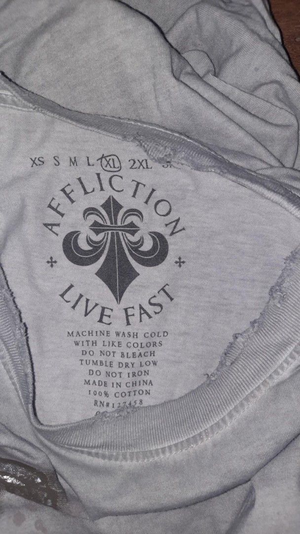 Affliction Live Fast Graphic Tee (Category: Tshirts & Polo Shirts ) located in Narvacan. Submitted by thrift_look (Listing ID 1420475010, Image 2). Description: - Affliction t-shirt. - Size: XL - Color: Gray - Material: 100% Cotton. - Features: Large graphic on back, smaller design on front..