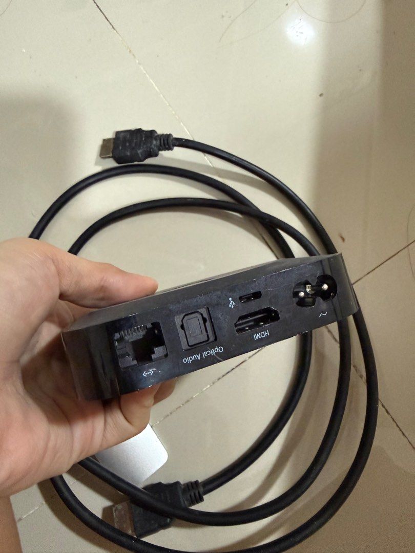Apple TV Box with Remote and Cables (Category: TV Parts & Accessories) located in Cabuyao City. Submitted by affordable_love_items (Listing ID 1420417136, Image 3). Description: - Apple TV box included - Comes with remote control, power cable, and HDMI cable - Ports: HDMI, Ethernet, Optical Audio - Features a menu button and navigation controls on the remote - Apple logo visible - Device is in good working condition.