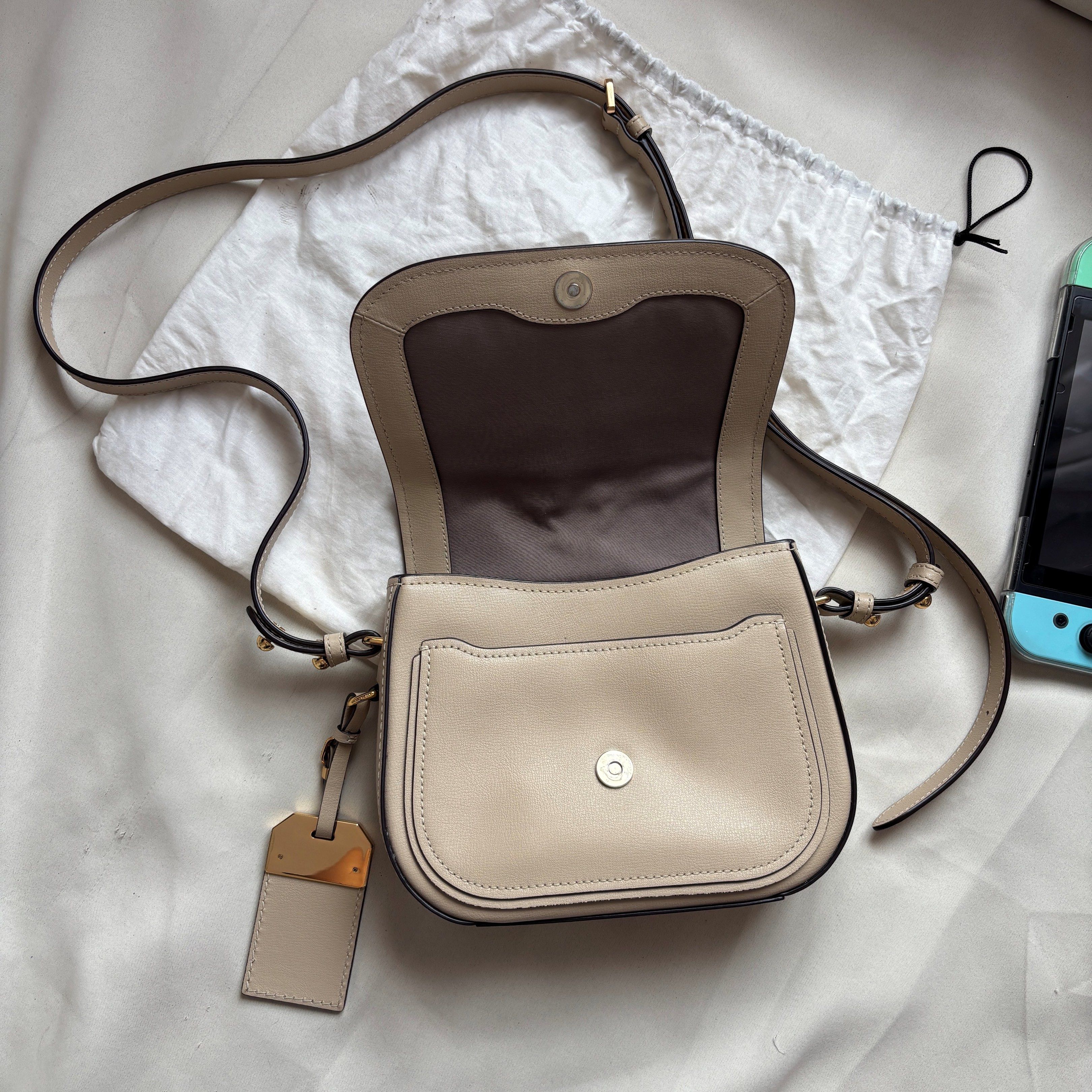 Authentic Marc Jacobs Mini Rider Crossbody Bag (Category: Luxury Bags & Wallets) located in Binan City. Submitted by rr.stuff (Listing ID 1420538917, Image 3). Description: FIXED PRICE - Authentic Marc Jacobs crossbody bag, bought in Japan - Light beige exterior - Flap closure - Gold-tone hardware - Interior pocket - Includes dust bag and original care booklet and card - some scratches and crusted leather on the gold tag - some black leather lini