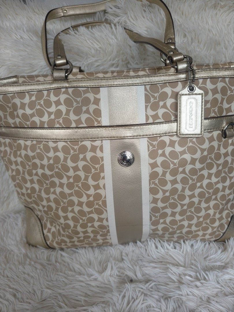 Authentic Coach Signature Baby Bag (Category: Luxury Bags & Wallets) located in Imus. Submitted by desvasquez (Listing ID 1420450605, Image 2). Description: - Coach tote bag - Signature pattern - Gold-tone trim and handles - Main compartment with zip closure - Multiple interior pockets - Purple interior lining - Includes Coach hang tag - Center stripe detail -L17 inches, H-14 inches, W-4 inches -in very good condition - minimal signs of use.