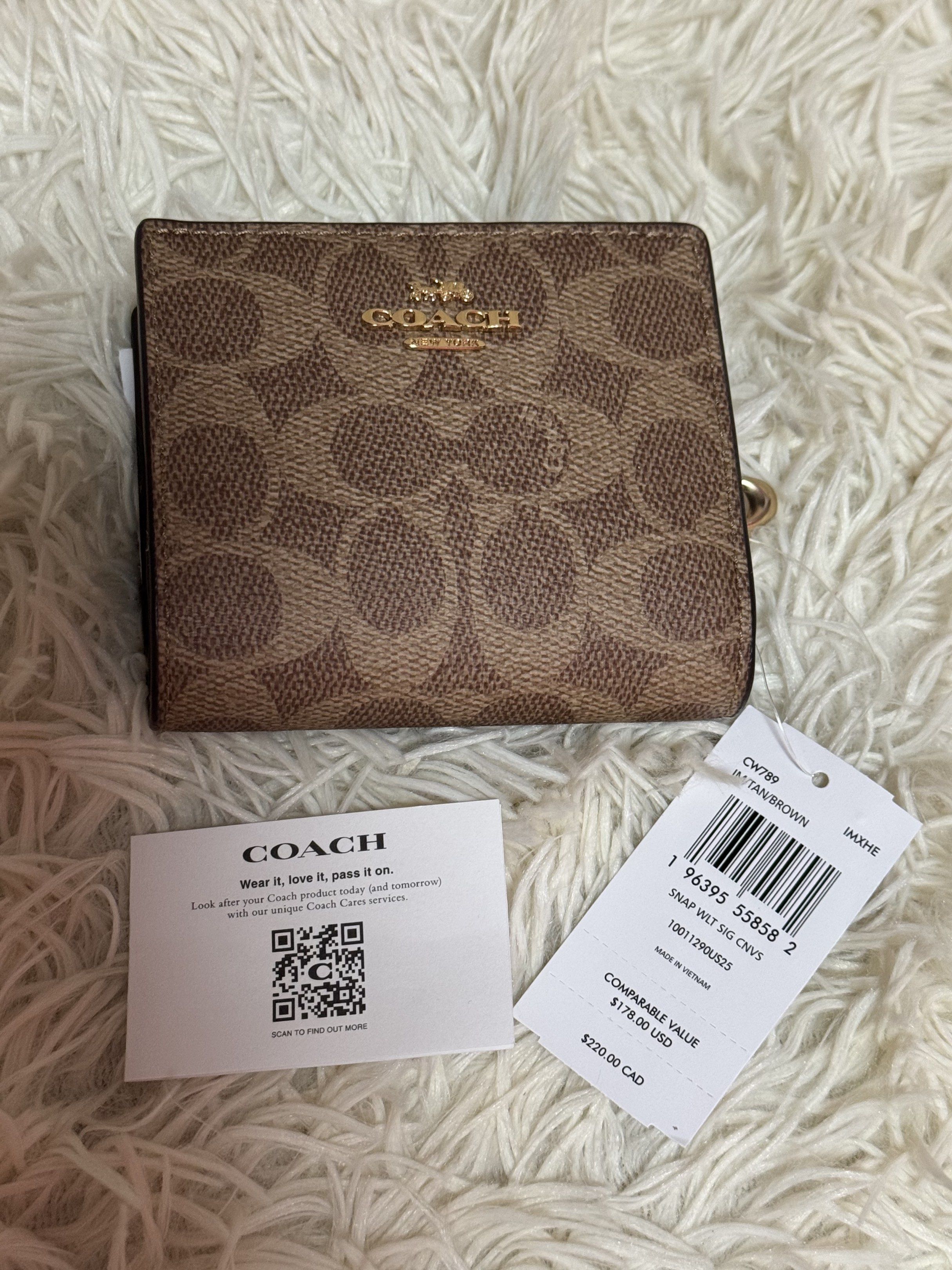 Coach Snap Wallet in Signature Canvas (Category: Luxury Bags & Wallets) located in Rodriguez. Submitted by nancyb13 (Listing ID 1420501139, Image 1). Description: Coach snap wallet features the signature canvas pattern in brown. It has multiple card slots, a clear ID window, and a zippered coin compartment. The wallet includes a Coach hang tag and a gold-tone zipper. The comparable value is $178.00 USD / $220.00 CAD..