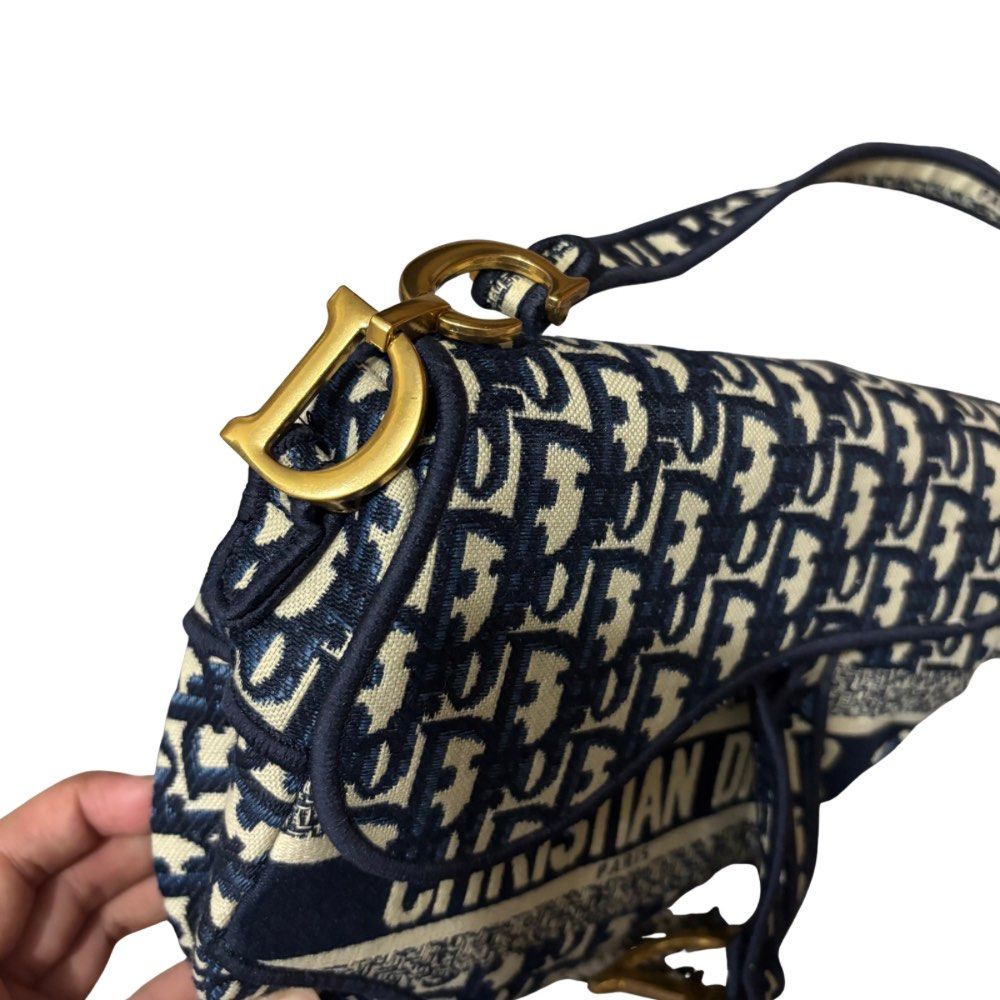 Dior Saddle Bag Blue Oblique (Category: Luxury Bags & Wallets) located in Manila. Submitted by poorstazy (Listing ID 1420500884, Image 2). Description: - Authentic Dior Saddle Bag - Blue oblique canvas - Signature 'D' charm - Top handle - Spacious interior with zip pocket - Iconic Dior pattern - Gold-tone hardware - Stylish and recognizable.