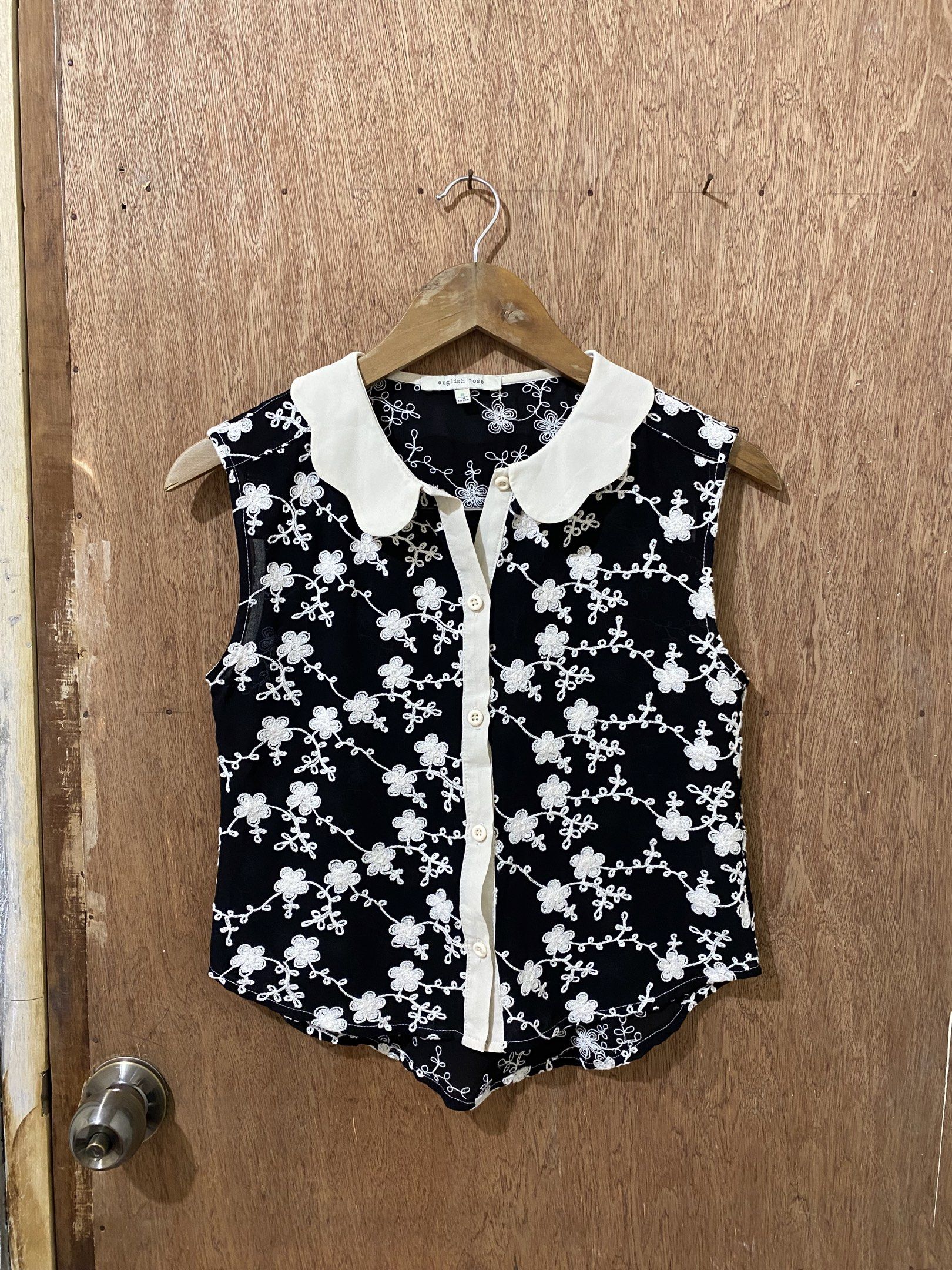 Embroidered Sleeveless Top with Peter Pan Collar (Category: Blouses) located in Guimba. Submitted by xeeeyaaaah (Listing ID 1420475275, Image 1). Description: - Sleeveless black top - Delicate floral embroidery - White Peter Pan collar - Button-down front - Lightweight material - Curved hemline - Feminine design.