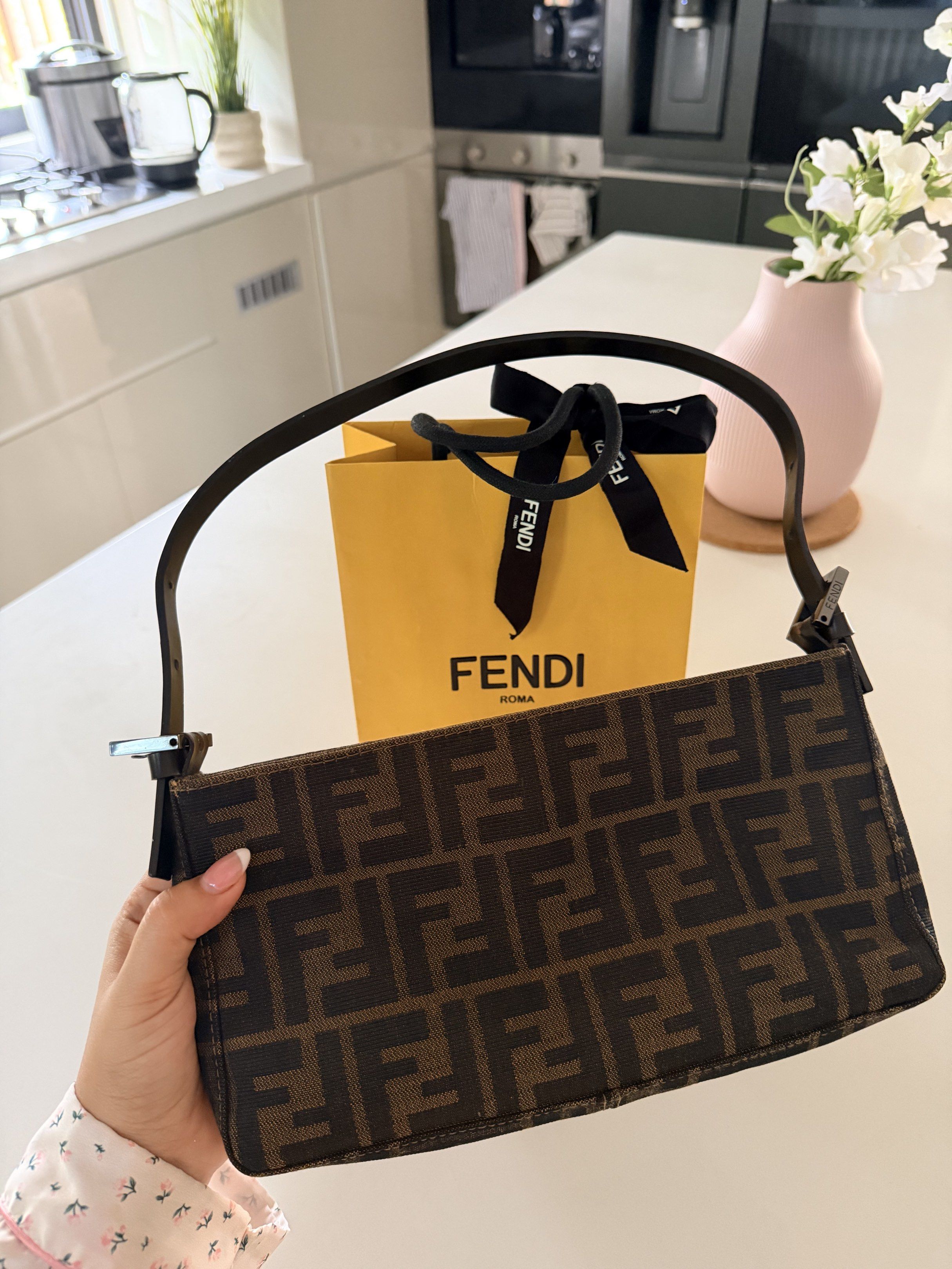 Fendi Baguette Bag (Category: Luxury Bags & Wallets) located in Apalit. Submitted by lunakobe (Listing ID 1420422626, Image 2). Description: - Authentic Fendi Baguette bag - Features the iconic FF logo pattern - Comes with Fendi shopping bag and ribbon - Brown leather strap - Silver hardware - A stylish and classic accessory.