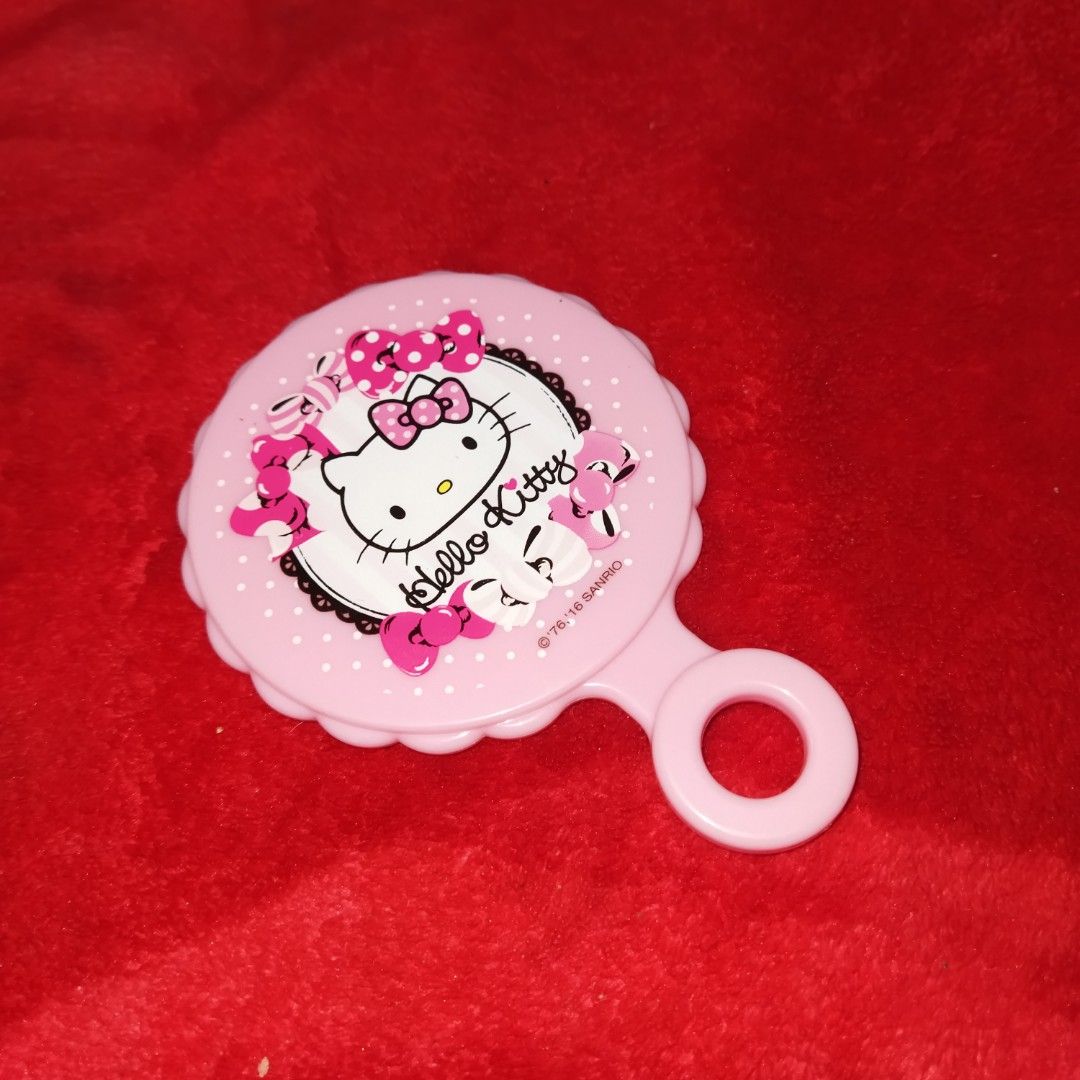 Hello Kitty Hand Mirror (Category: Mirrors) located in Santa Cruz. Submitted by madonnaching (Listing ID 1420533193, Image 1). Description: - Kitty design hand mirror - Pink scalloped frame - Clear reflection - Features Kitty's face and bow - Includes a handle with a ring - Cute and functional accessory.