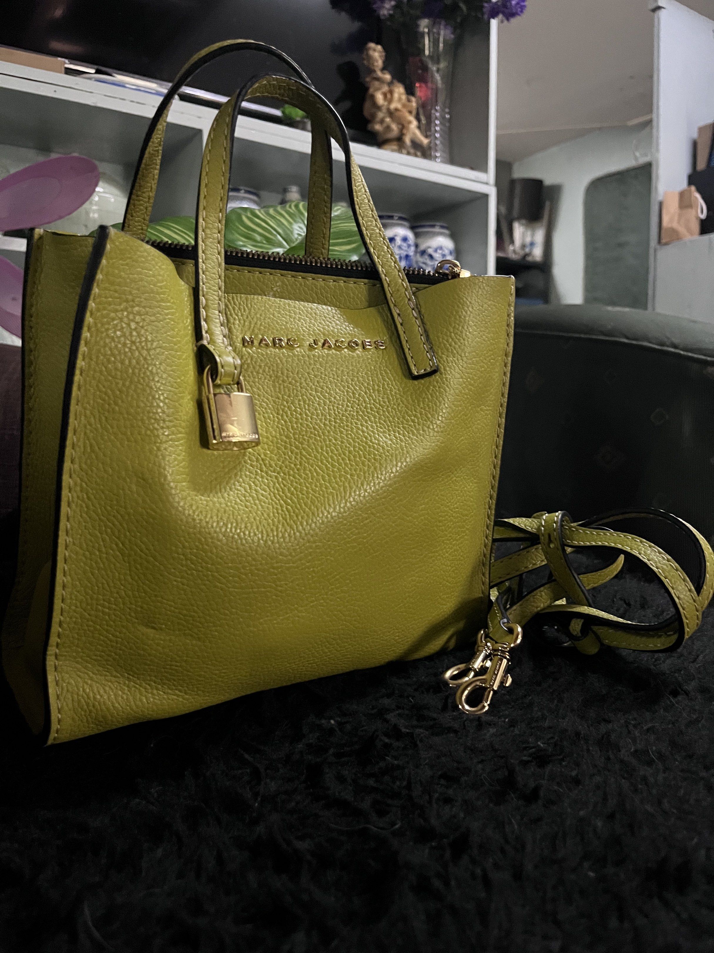 Marc Jacobs The Mini Tote Bag (Category: Luxury Bags & Wallets) located in Quezon City. Submitted by retann (Listing ID 1420354931, Image 1). Description: - Marc Jacobs mini tote bag - Olive green textured exterior - Top handle and detachable shoulder strap - Zip closure with padlock detail - Gold-tone hardware - Perfect for daily use.
