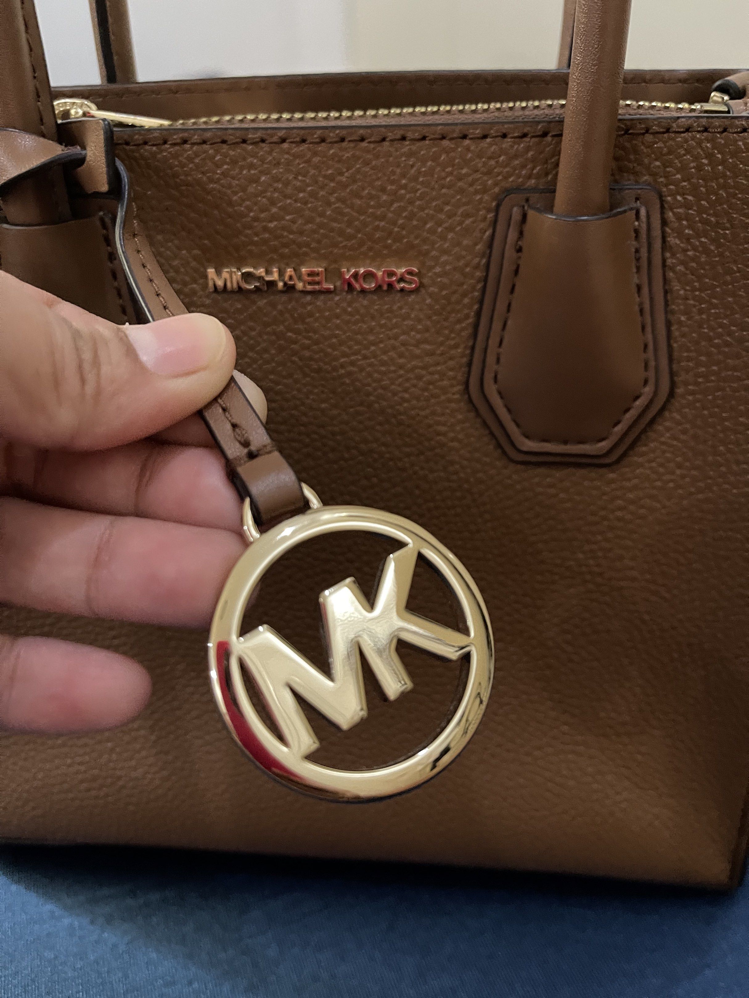 Michael Kors Mercer Small Top Handle Bag (Category: Luxury Bags & Wallets) located in Davao. Submitted by decluttering-with-leng (Listing ID 1420392968, Image 3). Description: - Michael Kors Mercer Small Top Handle Bag - Brown textured leather - Gold-tone hardware with MK logo - Top handle and detachable shoulder strap - Zip closure - Interior pocket - Includes original tag and receipt.