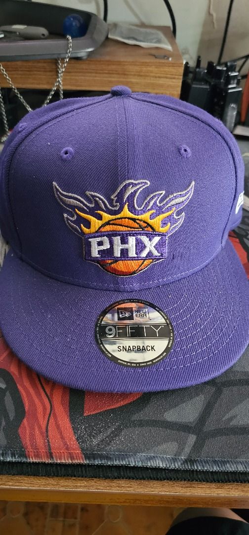 New Era 9Fifty Phoenix Suns Snapback Cap (Category: Caps & Hats) located in Pasay City. Submitted by bs_flatline (Listing ID 1420404916, Image 1). Description: - Official New Era 9Fifty cap - Phoenix Suns logo - Color: Purple with grey underbrim - NBA logo on the side - Adjustable snapback closure - Original New Era tag attached Bnew as displayed only on Shop. NO box. Cap only.