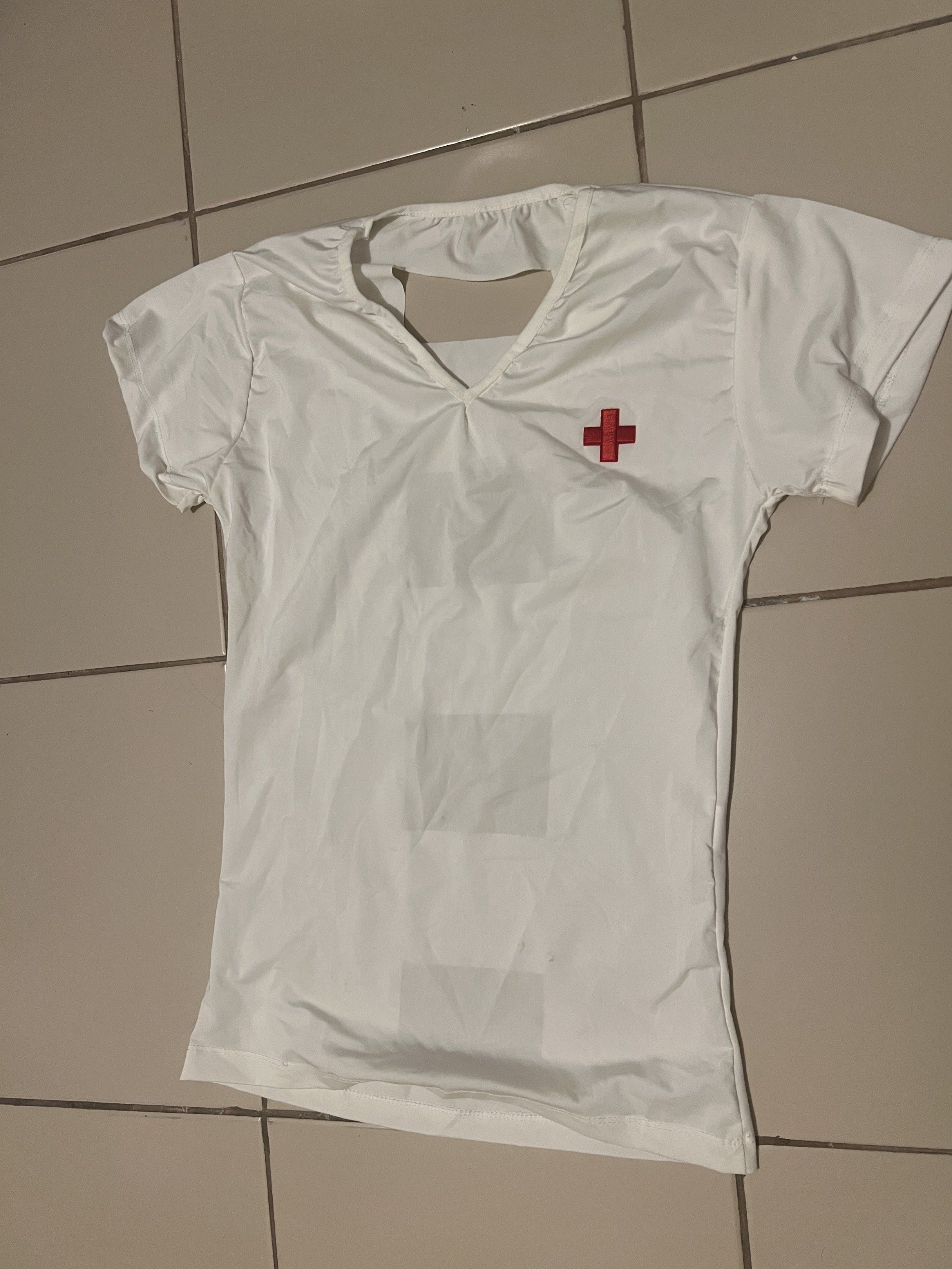 Nurse Costume White Top (Category: Others Tops) located in Cainta. Submitted by barbie714 (Listing ID 1420519129, Image 1). Description: - White nurse costume top - Features a red cross emblem - V-neck and short sleeves - Unique back cut-out design - Made of lightweight material - Ideal for costume parties and themed events.