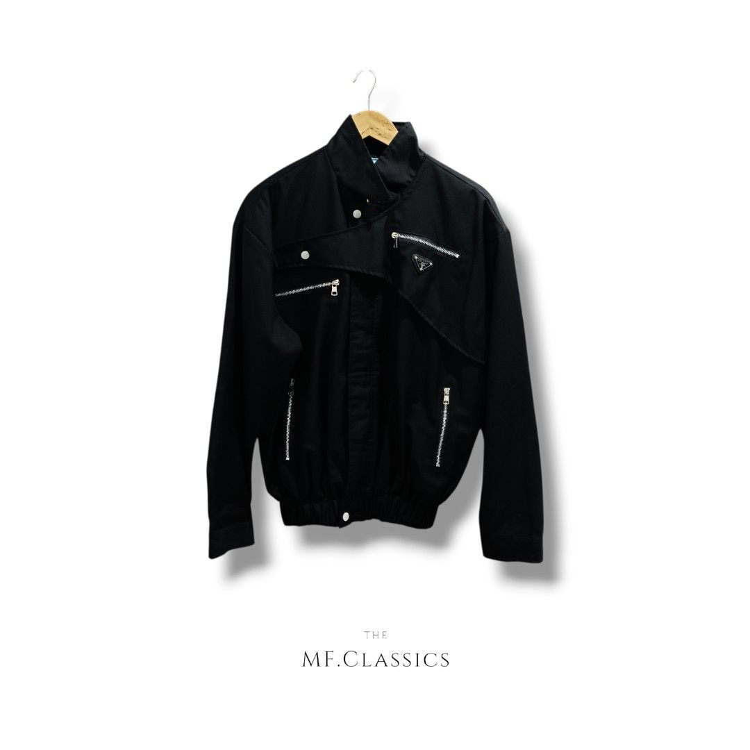 Prada Harrington Jacket (Black) (Category: Coats, Jackets and Outerwear) located in Manila. Submitted by mf.classics (Listing ID 1420444528, Image 1). Description: Prada black jacket with asymmetrical design. Features Prada logo and zip pockets. Classic style. Measurements: 26 Length & 25 Width Authenticity is not guaranteed.