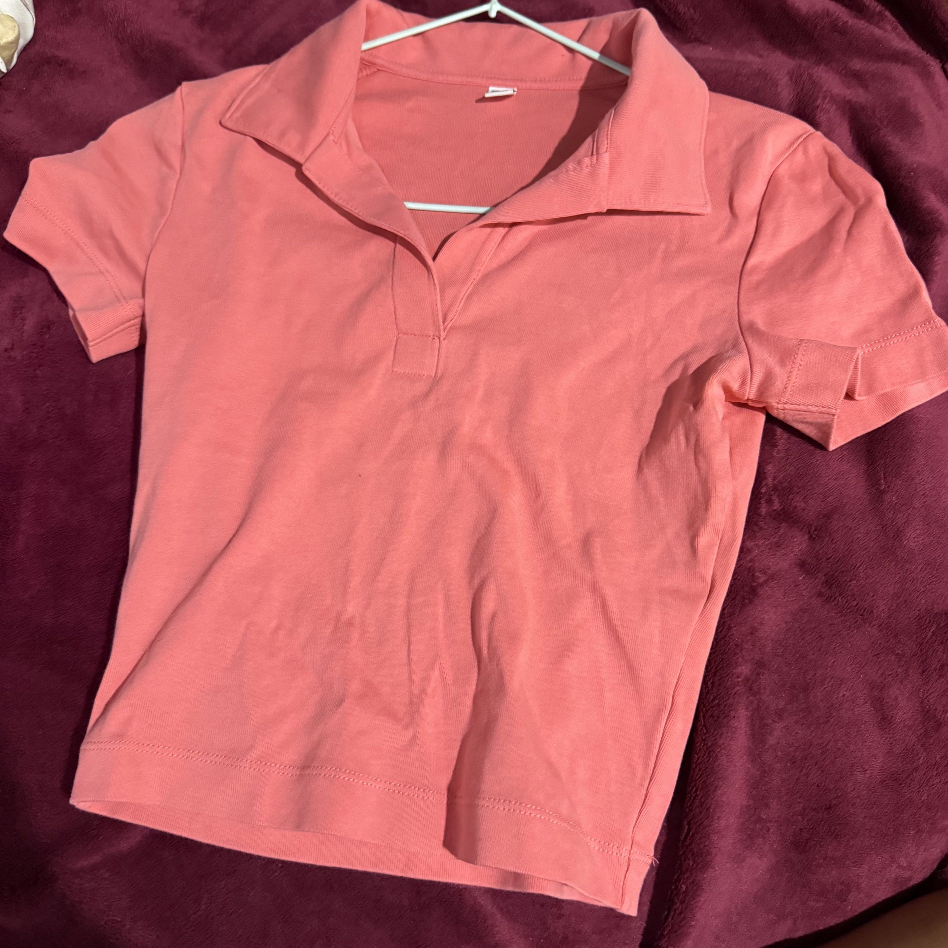 Preloved: Uniqlo Polo Shirt (Category: Shirts) located in Antipolo. Submitted by bookcycledph (Listing ID 1420536451, Image 3). Description: - Uniqlo coral polo shirt - Size: S - Features a collared neckline - Short sleeves - V-neck design - Made in Vietnam.