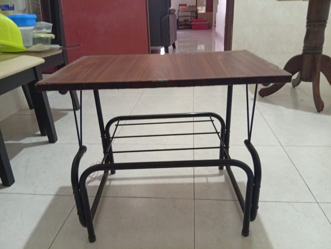 Small Study Table (Category: Tables & Sets) located in Kuala Lumpur. Submitted by mmmm985128 (Listing ID 1420366250, Image 1). Description: - Dark brown tabletop with a sleek black metal frame. - Features a convenient lower shelf for storage. - Dimensions: Approximately 2 feet long, 14 inches wide, and 1.7 feet high. - Ideal for small spaces. - Versatile use: Study table or side table..