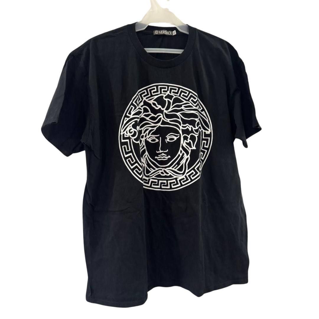 Versace Medusa Graphic Tee (Category: Tshirts & Polo Shirts ) located in Cainta. Submitted by declutteringceo (Listing ID 1420553870, Image 1). Description: - Black Versace t-shirt - Features a white Medusa head graphic on the front - Classic crew neck design - Short sleeves for a comfortable fit.