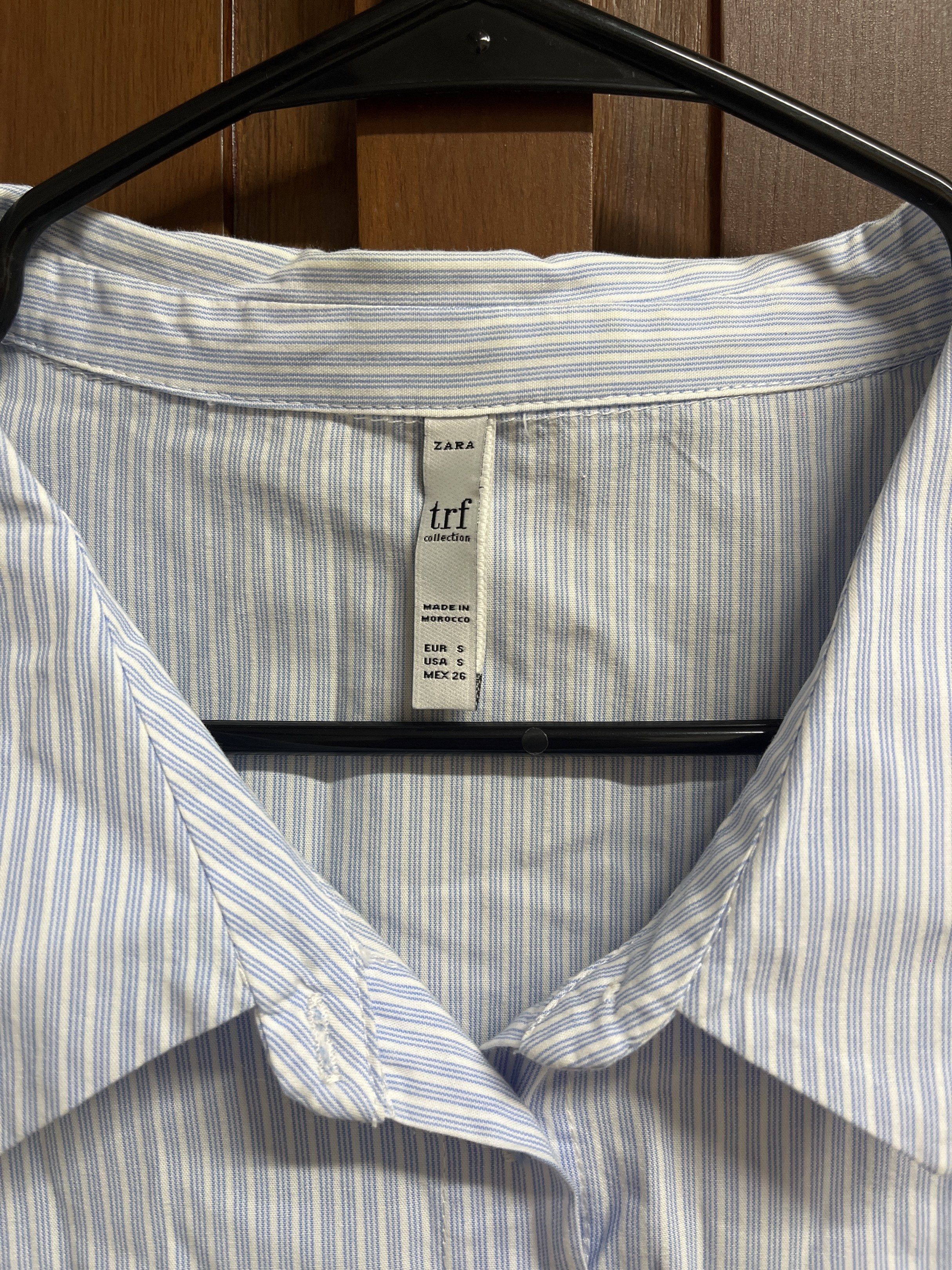 Zara TRF Striped Cropped Top (Category: Blouses) located in Muntinlupa City. Submitted by timttam (Listing ID 1420470611, Image 2). Description: - Zara TRF cropped top - Size: S - Features a light blue and white striped pattern - Collared neckline - Short sleeves - Button-down closure - Made in Morocco - missing one button.