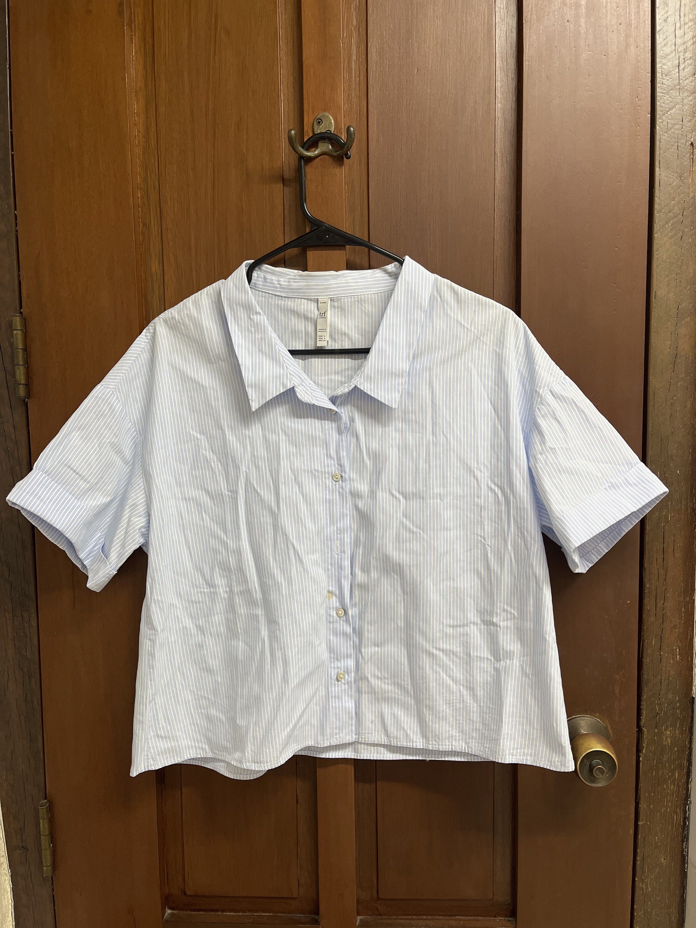 Zara TRF Striped Cropped Top (Category: Blouses) located in Muntinlupa City. Submitted by timttam (Listing ID 1420470611, Image 1). Description: - Zara TRF cropped top - Size: S - Features a light blue and white striped pattern - Collared neckline - Short sleeves - Button-down closure - Made in Morocco - missing one button.