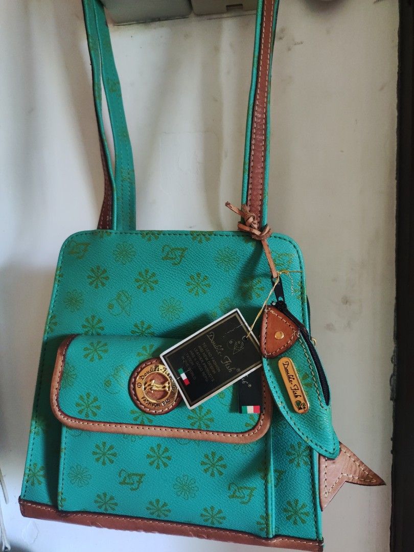 Double Fish 2 way Bag (Category: Luxury Bags & Wallets) located in Zamboanga. Submitted by Clairey03 (Listing ID 1420615860, Image 1). Description: - Double Fish crossbody bag - Vibrant teal color with floral pattern - Brown leather trim - Long, adjustable strap - Front pocket - Zipper closure - Gold Double Fish logo - Brand new with tag.