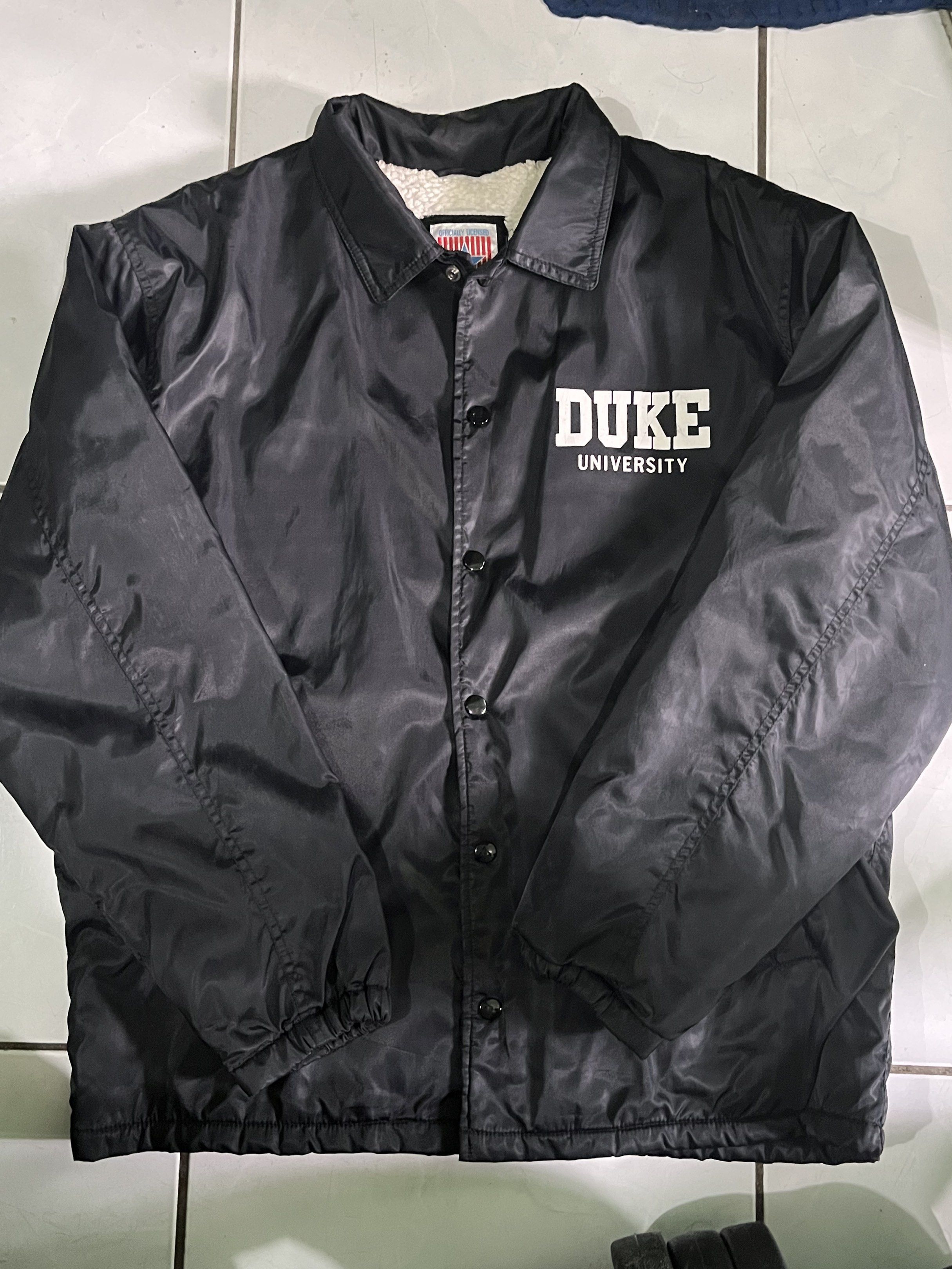 Duke University Warm Coach Jacket (Black) (Category: Coats, Jackets and Outerwear) located in Paranaque City. Submitted by BeyondRepair (Listing ID 1420608108, Image 2). Description: Duke University coach jacket. Size L. Button-up closure, collared neckline. Perfect pang rides and pang baguio or tagaytay. Color rate: 9/10 Plus shipping fee. Dimes: W 25 x L 29.