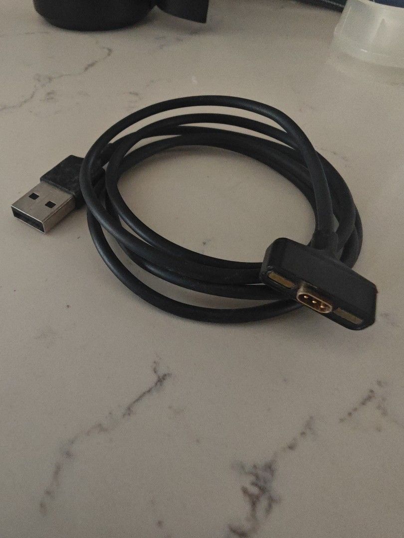 Fitbit ionic charging cable (Category: Chargers & Cables) located in Singapore. Submitted by natlba (Listing ID 1420644094, Image 1). Description: Black cable with a USB connector on one end and a proprietary connector on the other. Perfect for charging or data transfer..
