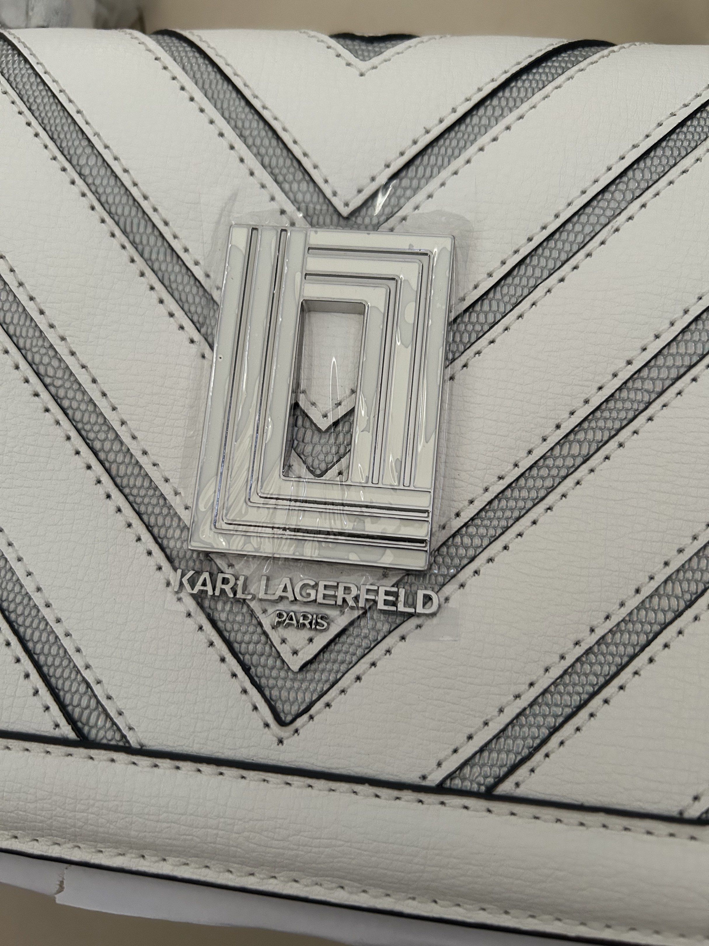 Karl Lagerfeld White Shoulder bag (Category: Luxury Bags & Wallets) located in Pasig City. Submitted by jrrhs (Listing ID 1420651149, Image 2). Description: - Karl Lagerfeld shoulder bag - White exterior with chevron design - Detachable strap - Silver-tone logo - Interior: Card holder and quote - Comes with tags - Comparable value: "$228".