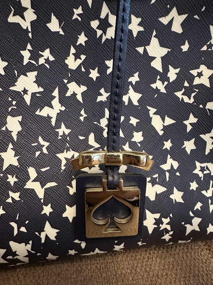 Kate Spade Star Print Satchel (Category: Luxury Bags & Wallets) located in Quezon City. Submitted by sofieegee (Listing ID 1420651482, Image 2). Description: - Kate Spade satchel - Navy and white star print - Includes Kate Spade logo charm - Interior: zip pocket - Lined with navy fabric with Kate Spade New York logo - Zip closure - has flaws see photos.