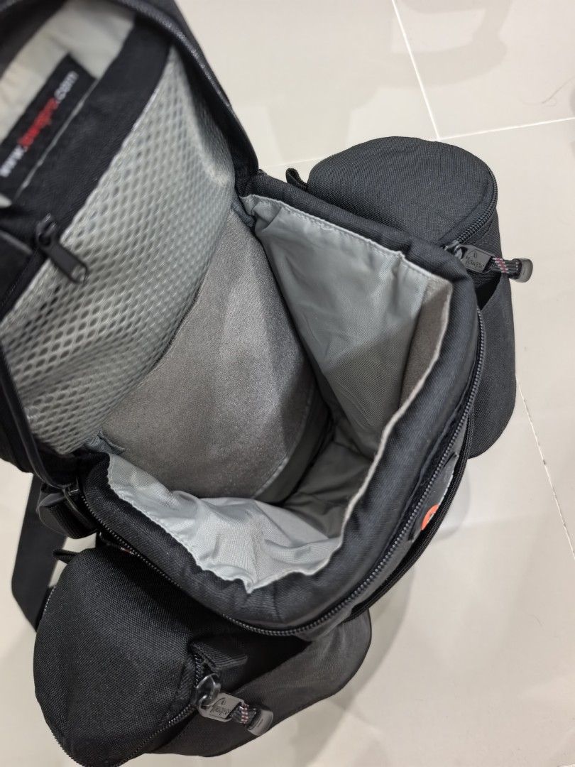 Lowepro Off Trail 2 Camera Bag (Category: Camera Bags & Carriers) located in Quezon City. Submitted by studiojpeg (Listing ID 1420619077, Image 2). Description: Lowepro Off Trail 2 camera bag is designed for outdoor photography. It features multiple compartments, including side pockets and a main compartment with a mesh lining. The bag has a black exterior and a sturdy strap for carrying. The Lowepro logo is visible on the front..