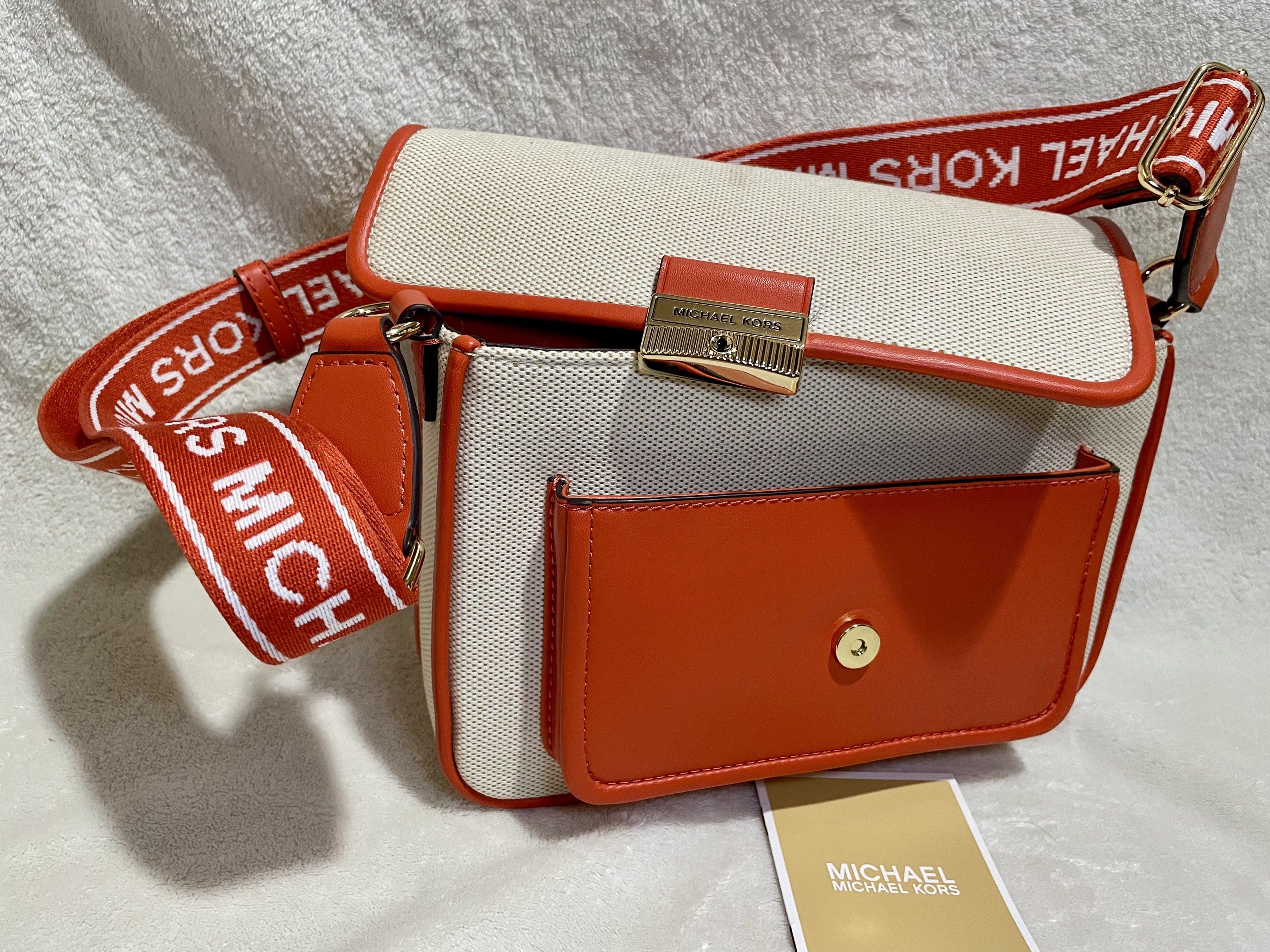 Michael Kors Bradshaw Pocket Messenger bag (Category: Luxury Bags & Wallets) located in Mandaluyong City. Submitted by wysluxe (Listing ID 1420596176, Image 1). Description: - Original Michael Kors crossbody bag - Red Clay White - Canvas body with orange leather accents - Matching strap with Michael Kors logo - Front pocket - Main compartment with zipper closure - Includes care card - 24x16x6cm.