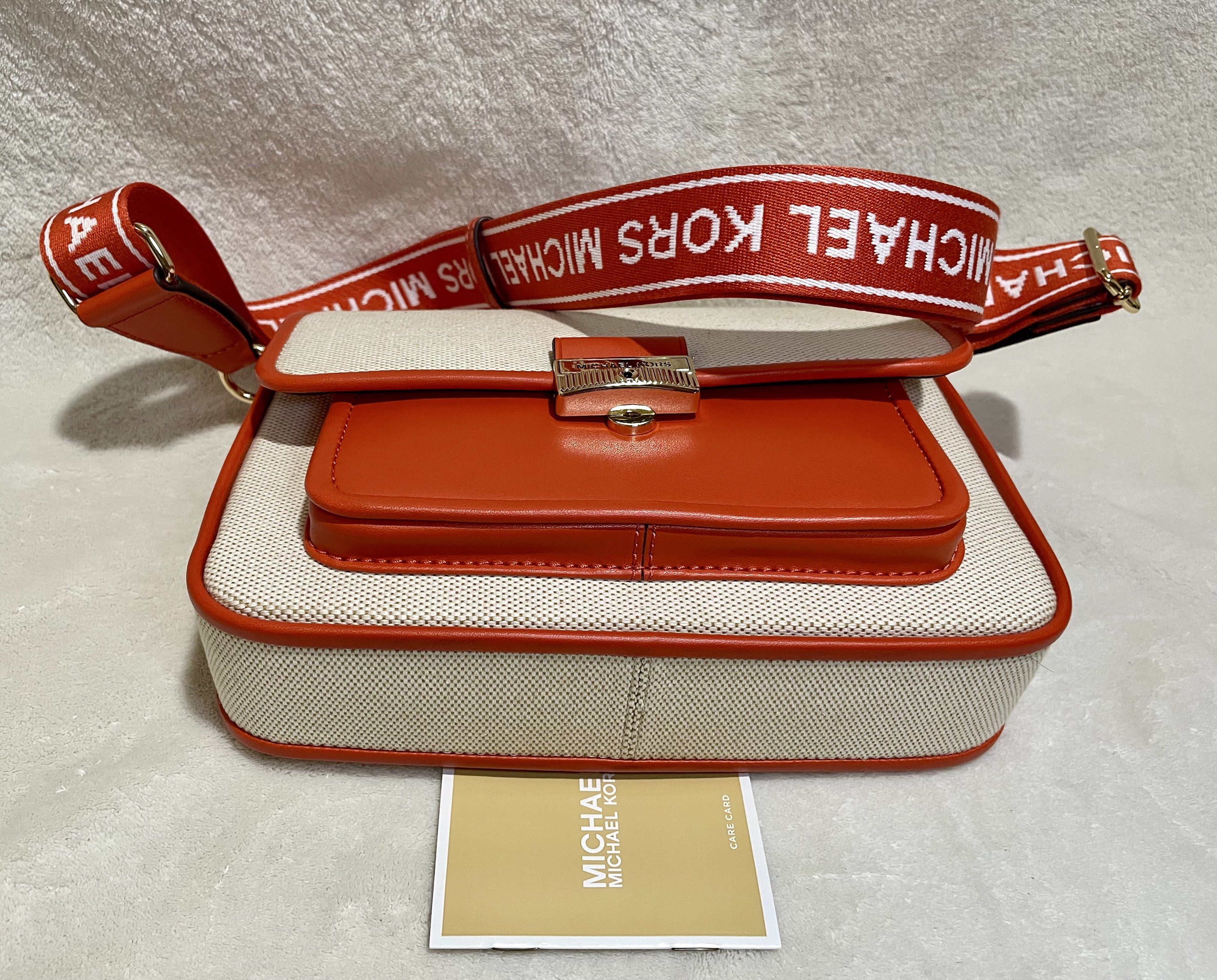 Michael Kors Bradshaw Pocket Messenger bag (Category: Luxury Bags & Wallets) located in Mandaluyong City. Submitted by wysluxe (Listing ID 1420596176, Image 2). Description: - Original Michael Kors crossbody bag - Red Clay White - Canvas body with orange leather accents - Matching strap with Michael Kors logo - Front pocket - Main compartment with zipper closure - Includes care card - 24x16x6cm.