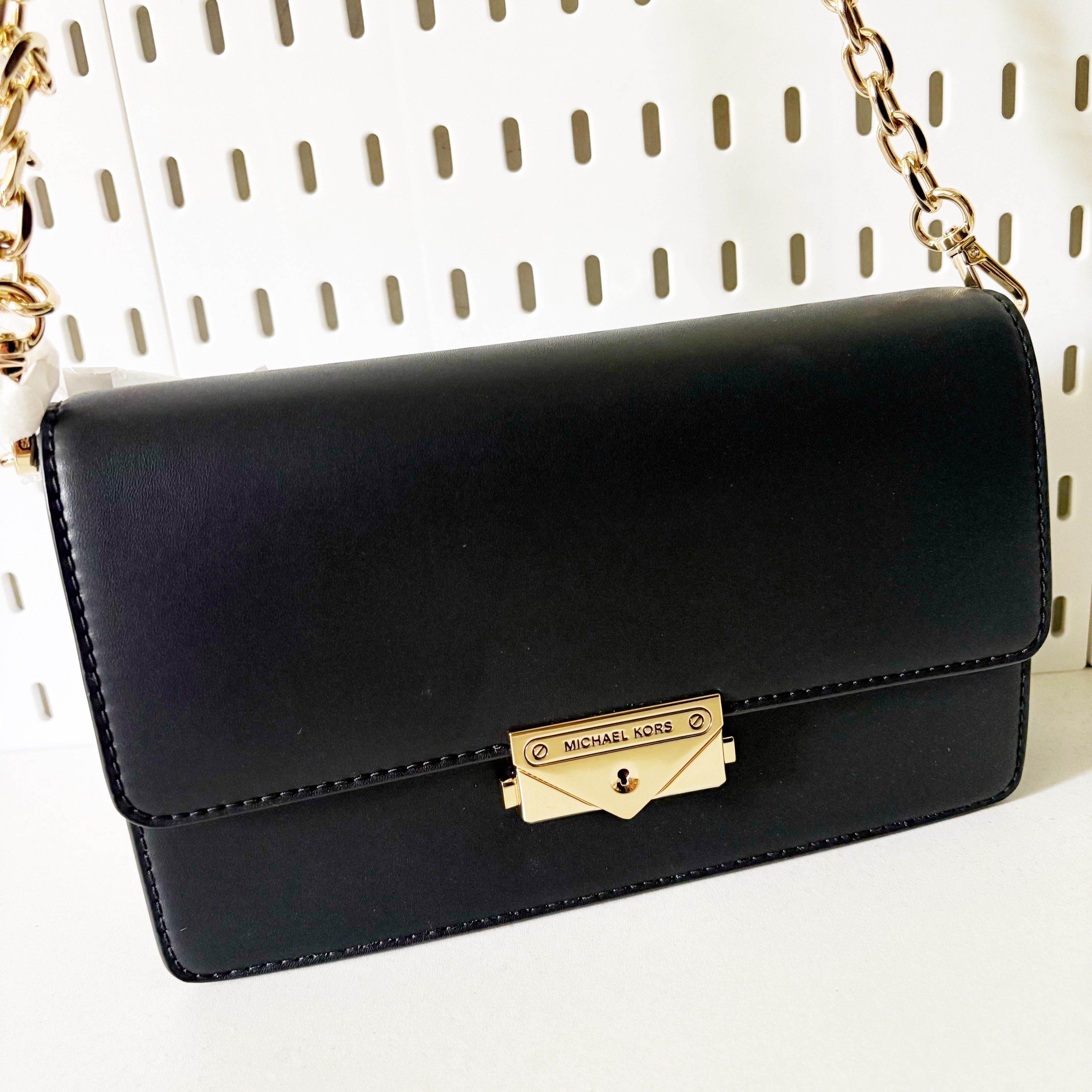 Michael Kors Cece Chain Clutch Bag (Category: Luxury Bags & Wallets) located in Caloocan City. Submitted by _yownice (Listing ID 1420653900, Image 1). Description: Michael Kors Cece Chain Clutch Bag 100% original Onhand and ready to ship Actual photos and final price posted. Details: - Sleek black design - Gold-tone chain strap and hardware - Flap closure with Michael Kors logo - Detachable strap included - Interior with multiple compartments.