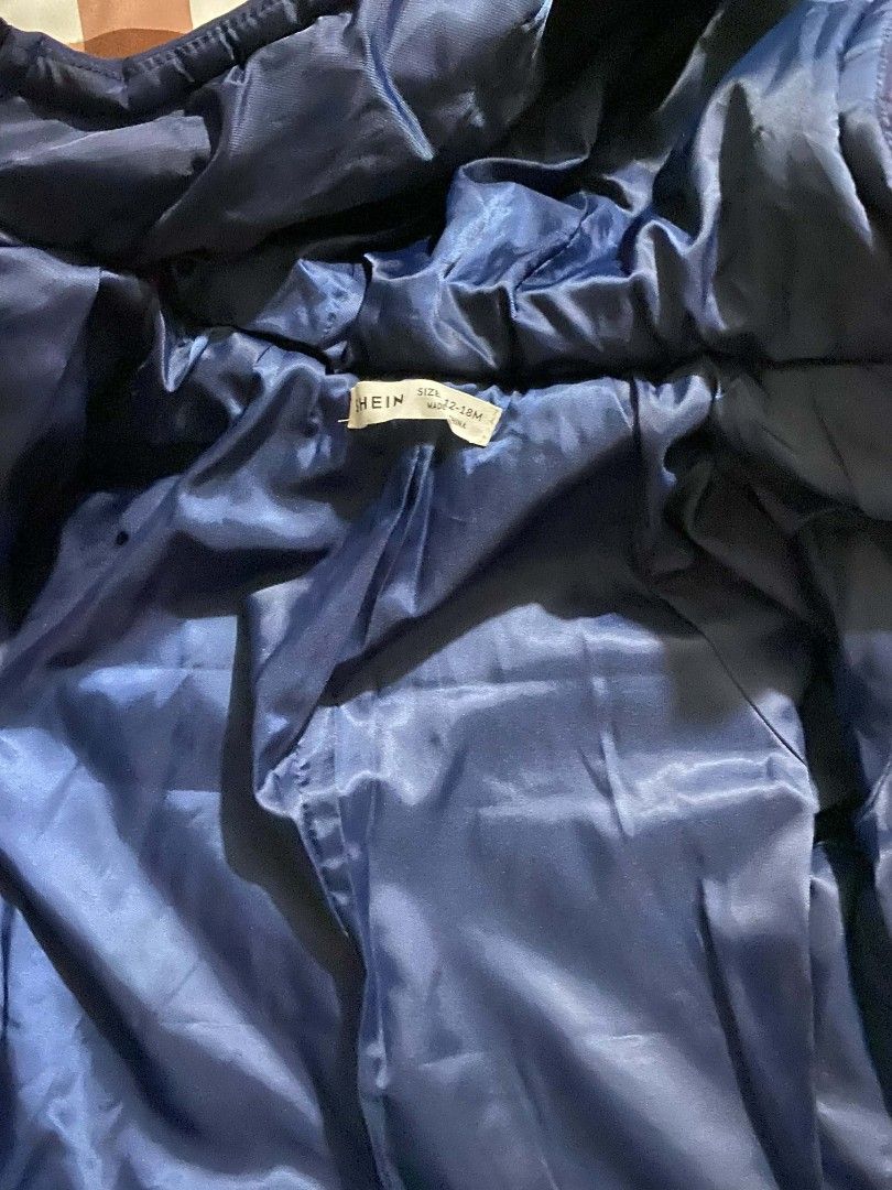 Shein Kids Padded Jacket with Hood (Category: Babies & Kids Fashion) located in Taguig. Submitted by tan0115 (Listing ID 1420712503, Image 2). Description: Never nagamit. Sinukat lang. Shein jacket features a navy blue and white color block design. It has a hood and two front pockets. The jacket is padded for warmth and has a zipper closure. The interior lining is a shiny navy blue material. .
