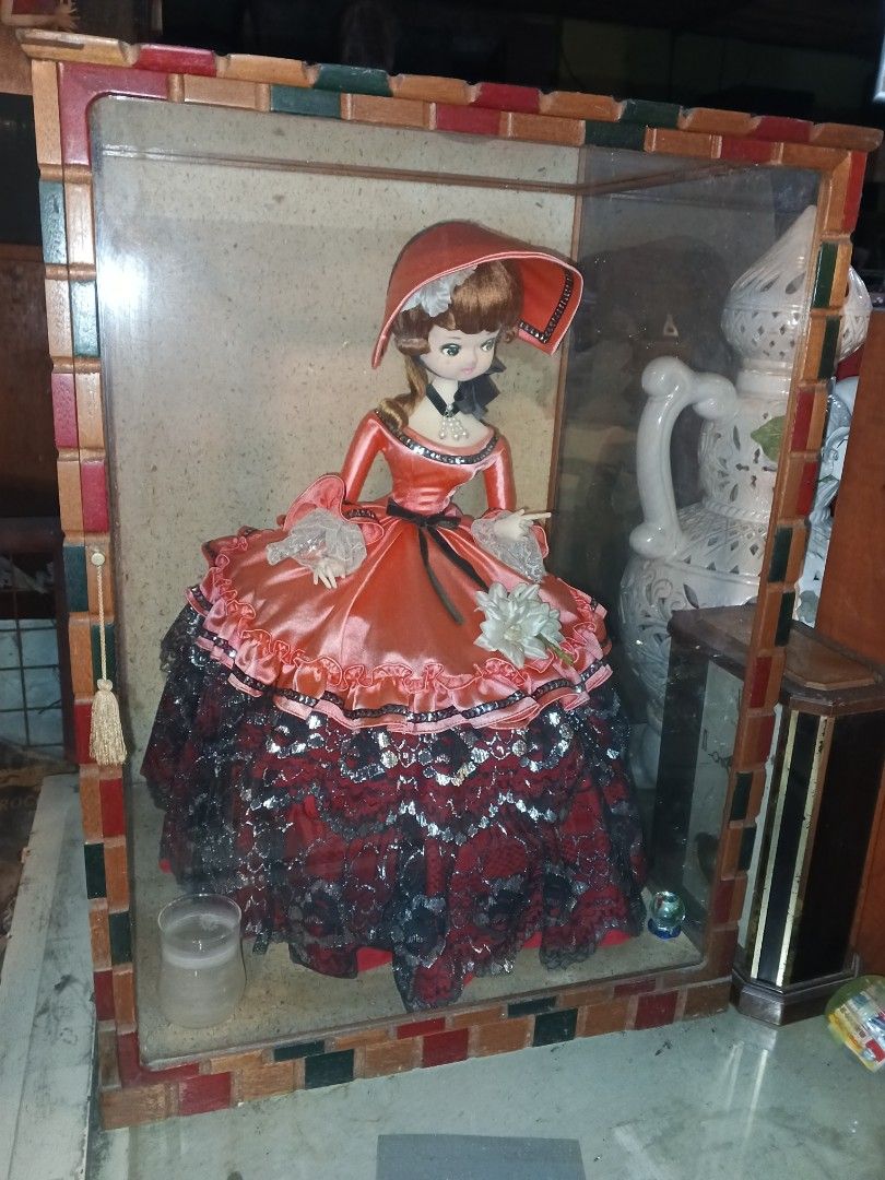 Big Vintage Doll in Display Case (Category: Vintage Collectibles) located in Caloocan City. Submitted by gemmareas571129 (Listing ID 1420741221, Image 2). Description: - Vintage doll in decorative display case - Doll is wearing a red and black dress and hat - Display case features a colorful tiled frame - Includes a small candle holder.