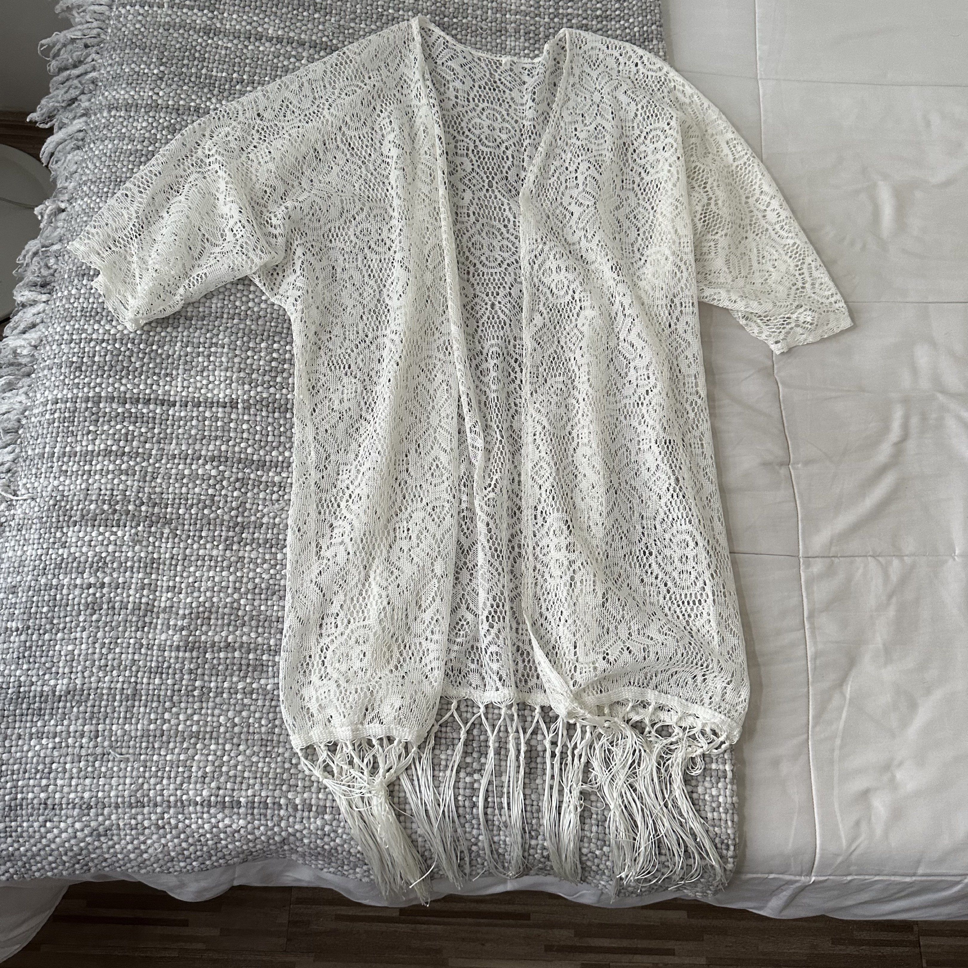 White Lace Kimono with Fringe (Category: Coats, Jackets and Outerwear) located in Marilao. Submitted by extra_stuff (Listing ID 1420583084, Image 1). Description: - White lace kimono - Flowing design - Short sleeves - Long, open front - Delicate fringe hem - Versatile for layering or beach cover-up.