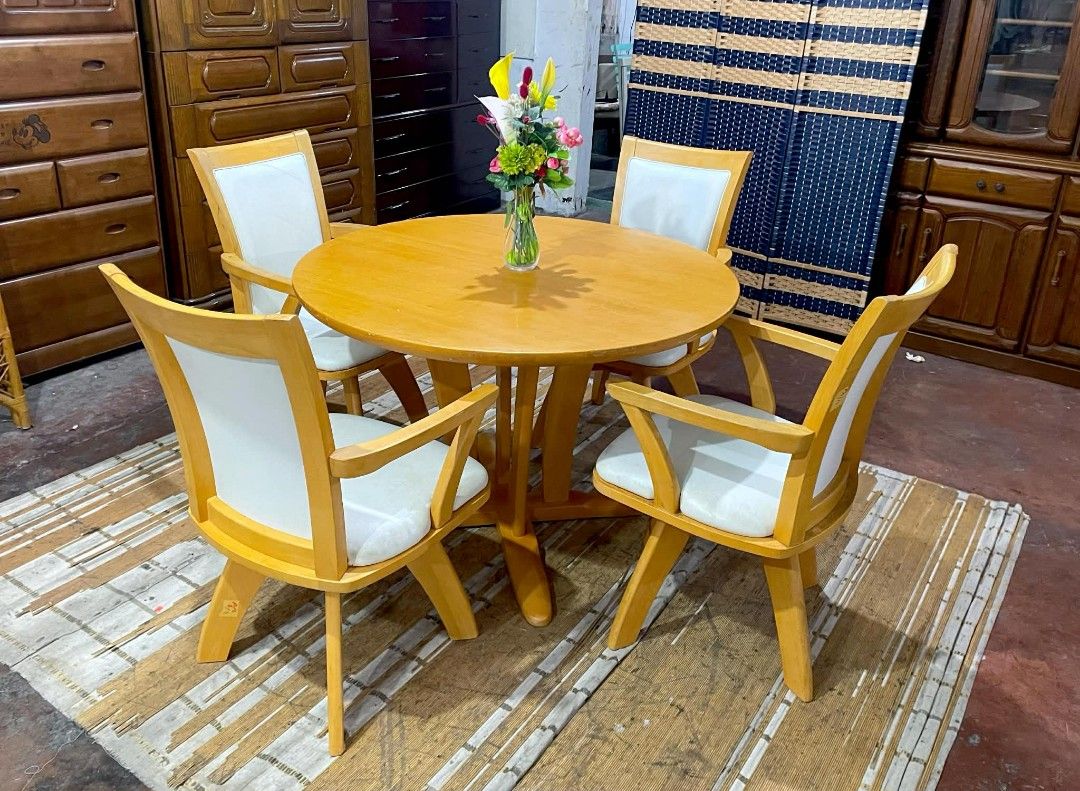 Wooden Round Dining Table with Swivel Chairs (Category: Tables & Sets) located in Quezon City. Submitted by kimmy026 (Listing ID 1420618256, Image 3). Description: Dining set includes a round wooden table and four swivel chairs. The table has a light wood finish and a unique base design. The chairs have white cushioned seats and backs. Table dimensions: H-28, D-41.5 inches. Swivel chair dimensions: H-17/35, L-21.5, W-17.5 inches..