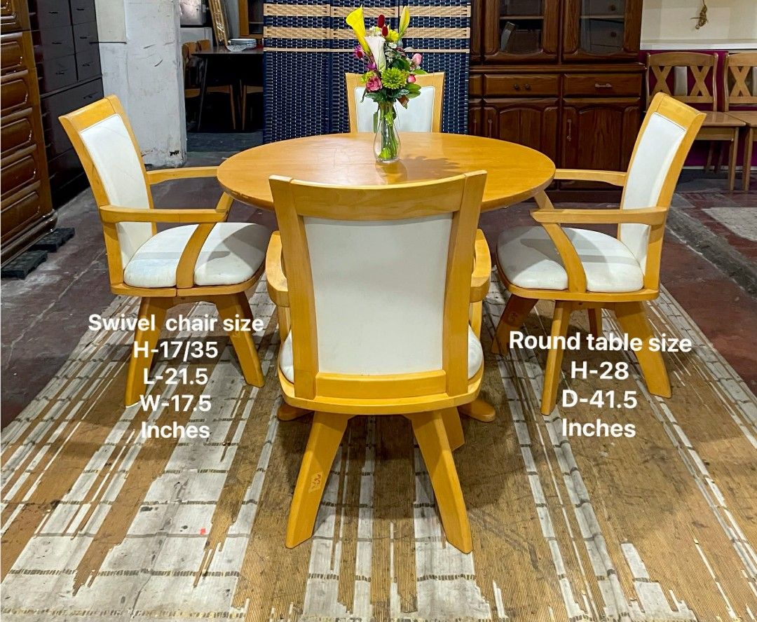 Wooden Round Dining Table with Swivel Chairs (Category: Tables & Sets) located in Quezon City. Submitted by kimmy026 (Listing ID 1420618256, Image 1). Description: Dining set includes a round wooden table and four swivel chairs. The table has a light wood finish and a unique base design. The chairs have white cushioned seats and backs. Table dimensions: H-28, D-41.5 inches. Swivel chair dimensions: H-17/35, L-21.5, W-17.5 inches..