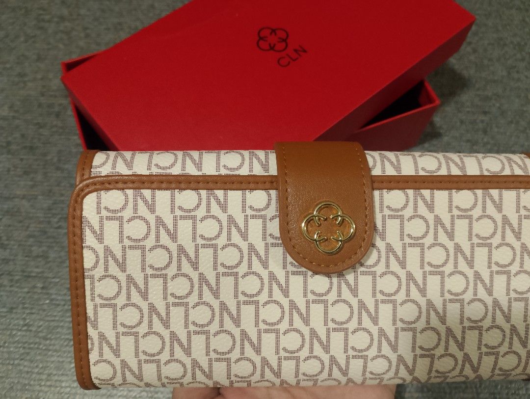 CLN Wallet with Box (Category: Wallets & Card holders) located in Makati City. Submitted by tagzmai (Listing ID 1424100282, Image 3). Description: - CLN wallet with a brown and white design - Gold-colored emblem and snap closure - Includes original box and dust bag - Unused condition - Multiple compartments for cards and cash.