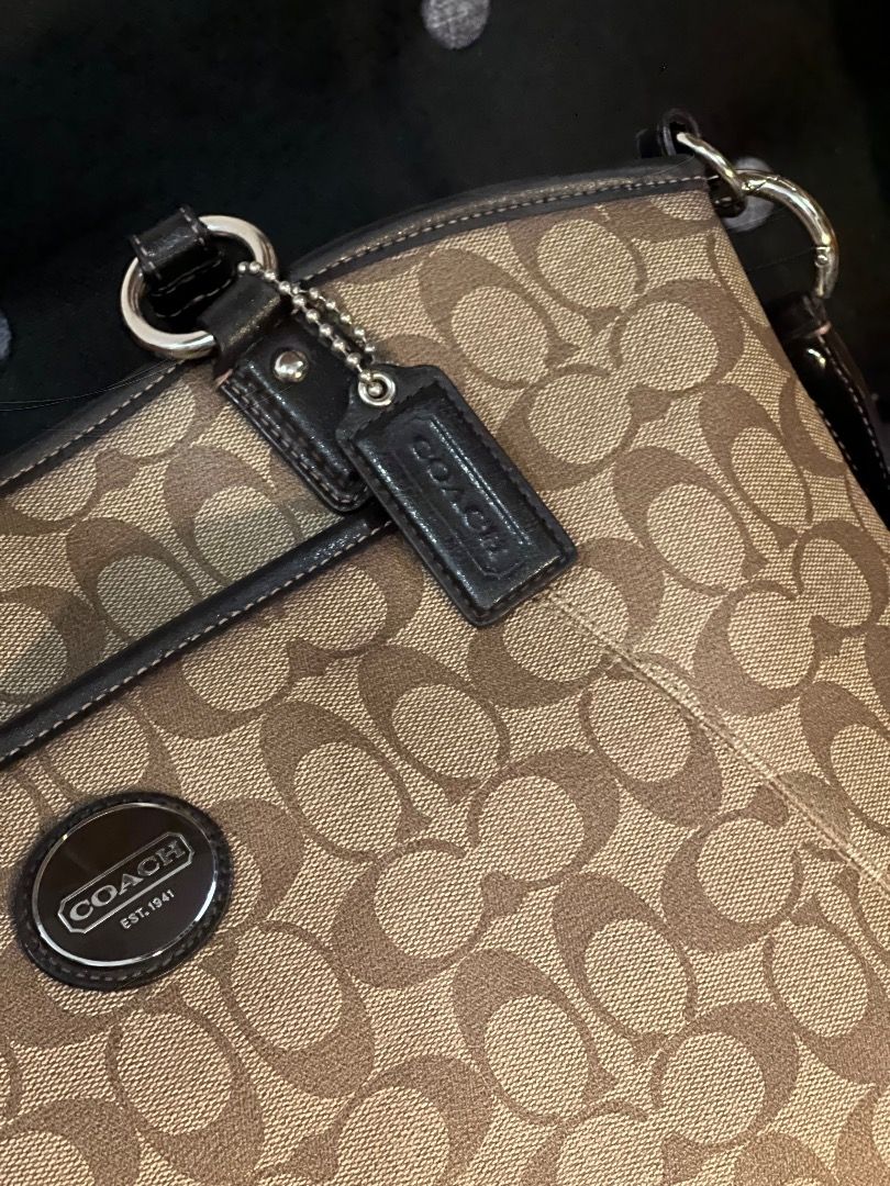 Coach Signature Shoulder Bag (Category: Luxury Bags & Wallets) located in Quezon City. Submitted by just.loveclub (Listing ID 1424155631, Image 2). Description: - Coach shoulder bag - Signature pattern (brown and tan) - Top handle and detachable shoulder strap - Silver-tone hardware - Zip closure - Spacious interior - Includes Coach hangtag.