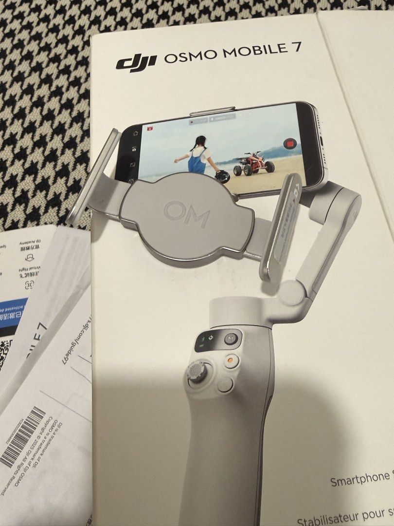 DJI Osmo Mobile 7 Gimbal Stabilizer (Category: Gimbals & Stabilizers ) located in Taguig. Submitted by sellingsunsetph (Listing ID 1424066458, Image 3). Description: Tawad kayo ng tawad! Taasan ko pa nga presyo.🙄 - DJI Osmo Mobile 7 gimbal stabilizer - Includes original box and paperwork - Color: Gray - Condition: Good - Compatible with smartphones (as shown on box) - Features DJI logo.