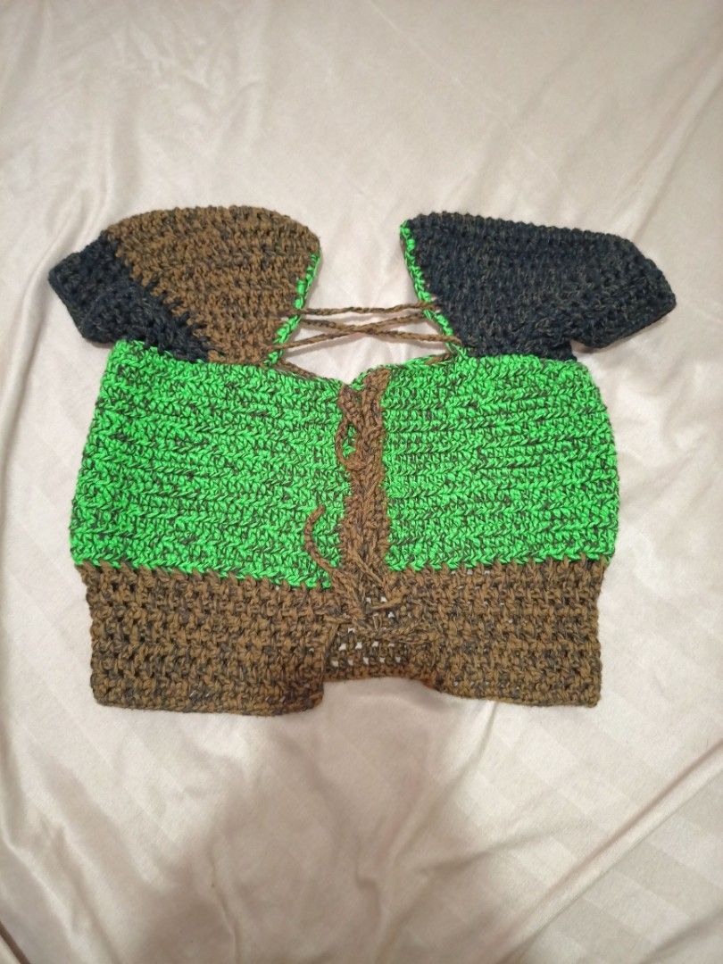 Handmade Crochet Top (Category: Sleeveless) located in Rizal. Submitted by declutterprod (Listing ID 1424001349, Image 2). Description: - Handmade crochet Top - Unique design with brown, green, and navy blue panels - Textured appearance - Features a tie-up detail - Adds a touch of handmade charm.