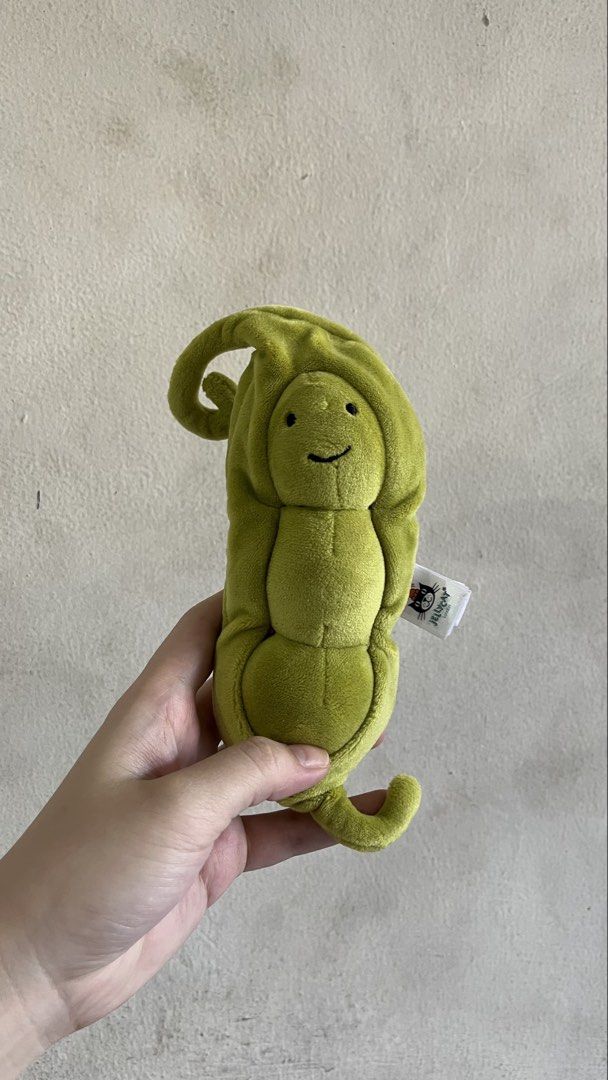 Jellycat Amuseable Pea in Pod Plush Toy (Category: Plushies & Soft Toys) located in Quezon City. Submitted by jellycooties (Listing ID 1423992205, Image 1). Description: - Jellycat Amuseable Pea in Pod plush toy - Features a smiling pea character - Nestled inside a soft, green pod - Includes the Jellycat tag - Has a loop at the top and a small tail at the bottom - Made of soft, plush material.