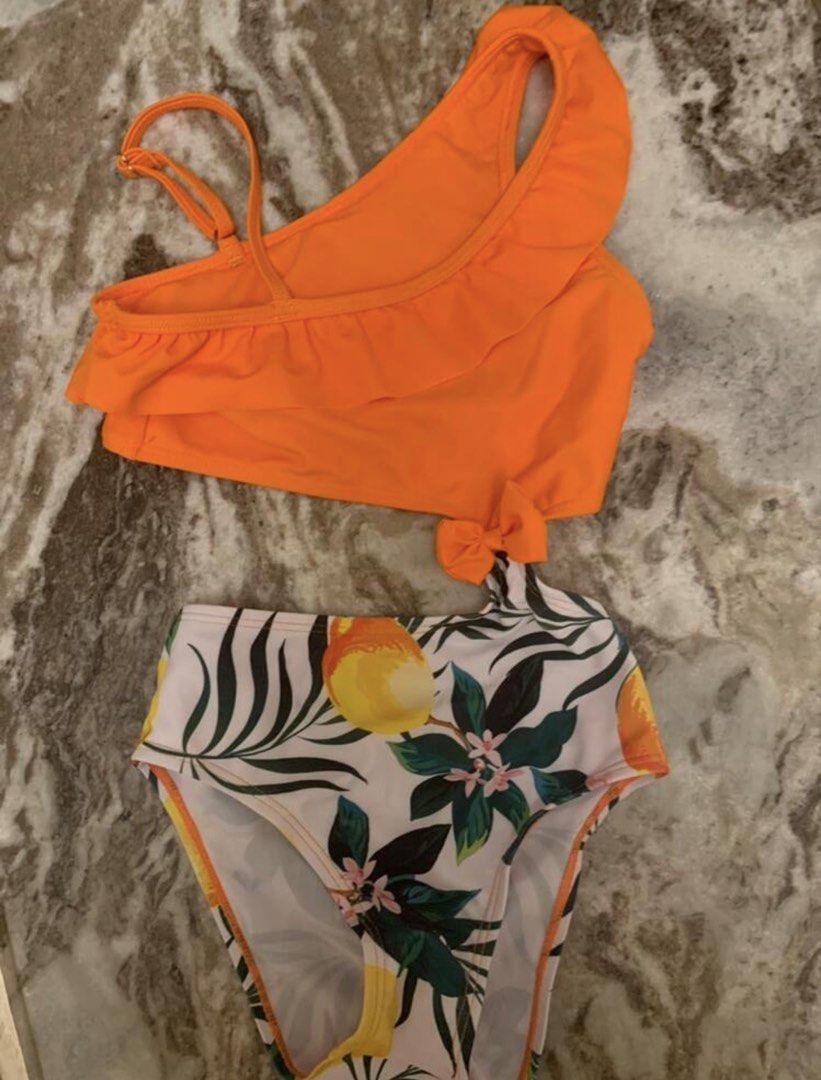 Orange Ruffle One-Shoulder Swimsuit (Category: Bikinis & Swimsuits) located in Taguig. Submitted by amara2021 (Listing ID 1423975636, Image 3). Description: - Vibrant orange top with ruffle detail - Fun lemon and leaf print bottom - Unique cutout design - Adorable bow accent - Ideal for beach or pool days 2-4 yrs old please see attached photo for body reference.