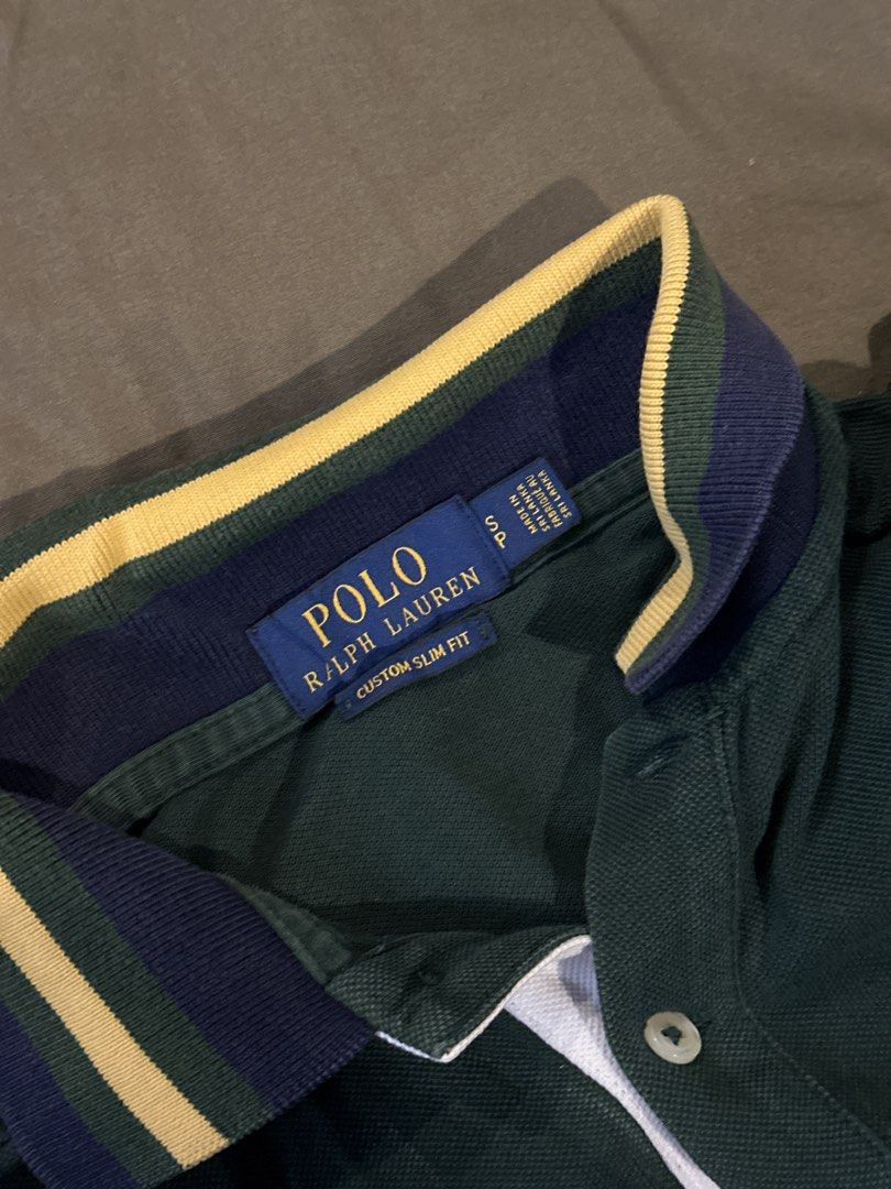 Ralph Lauren Polo Shirt (Category: Tshirts & Polo Shirts ) located in Manila. Submitted by knnyyyyy (Listing ID 1424131492, Image 2). Description: - Ralph Lauren polo shirt - Color: Green and navy blue - Classic polo collar with yellow and navy stripes - Features the iconic Ralph Lauren logo on the chest - Includes a crest on the left side - Navy blue sleeves with the number "2" - Button-up placket.