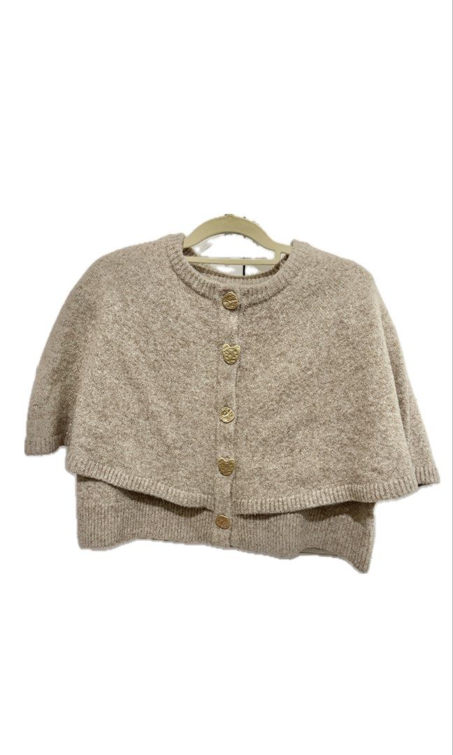 SHEIN Beige Poncho with Heart Buttons (Category: Coats, Jackets and Outerwear) located in Cavite. Submitted by mcxmcxmc (Listing ID 1424073577, Image 1). Description: - BRAND NEW. RFS: Size is too big for me. - SHEIN | Poeselle Cape - Beige color - Round neck design - Adorable heart-shaped buttons - Size: M (Model wears S) - Made of soft material - Great for layering .
